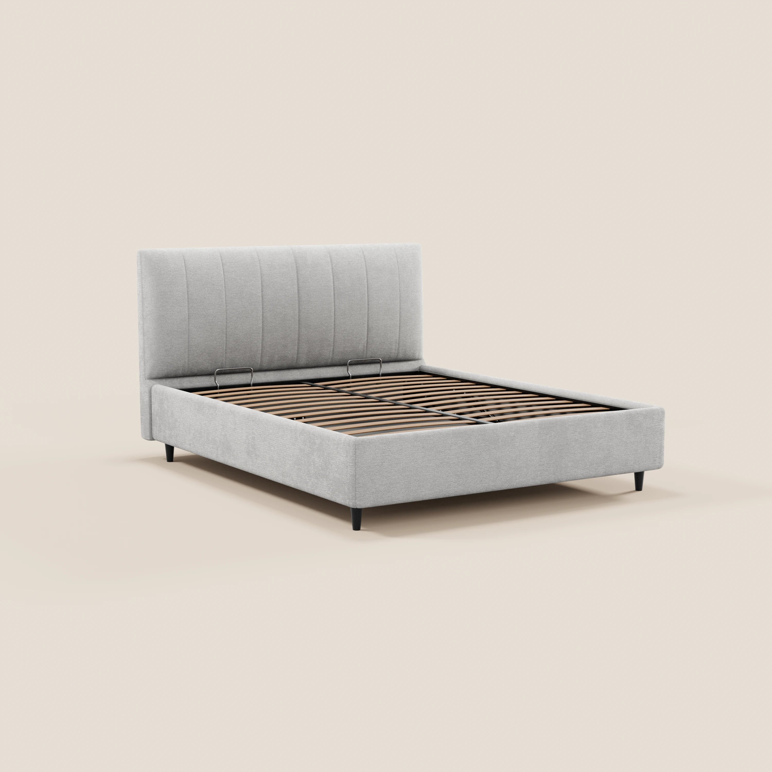 Il letto imbottito ONYX di Letti.store presenta una testiera imbottita verticale di colore grigio chiaro, certificata Oeko-Tex®, gambe corte nere e doghe in legno a vista per il materasso, raffigurato su uno sfondo bianco sporco.