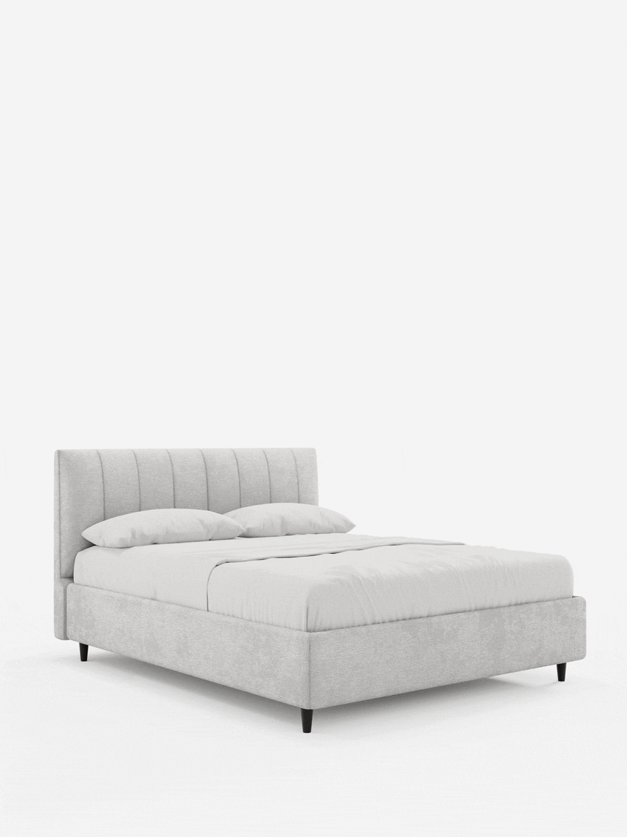 Il letto imbottito ONYX con contenitore e testiera verticale in tessuto certificato Oeko-Tex® è un letto imbottito di colore grigio chiaro, caratterizzato da una testiera alta con pannelli verticali, gambe corte di colore scuro e biancheria da letto ben rifinita su uno sfondo bianco.