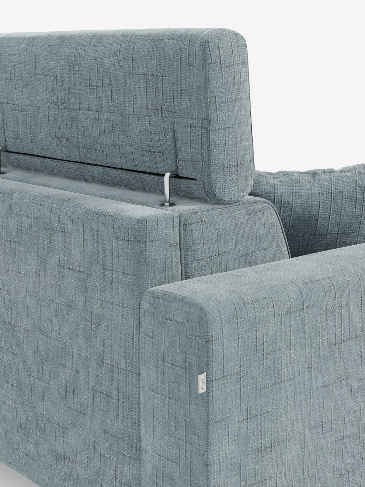 Primo piano del divano letto angolare Pegaso con poggiatesta reclinabili e penisola contenitore in tessuto jacquard smacchiabile T22 di Divani.Store, caratterizzato da un tessuto blu chiaro con trama in rilievo. L'immagine mette in risalto lo schienale regolabile con una barra di sostegno in metallo a vista, evidenziando il design funzionale tipico di un divano letto angolare. Il tessuto jacquard presenta un delicato motivo a quadrati e sul bracciolo è applicata una piccola etichetta in tessuto. Lo sfondo