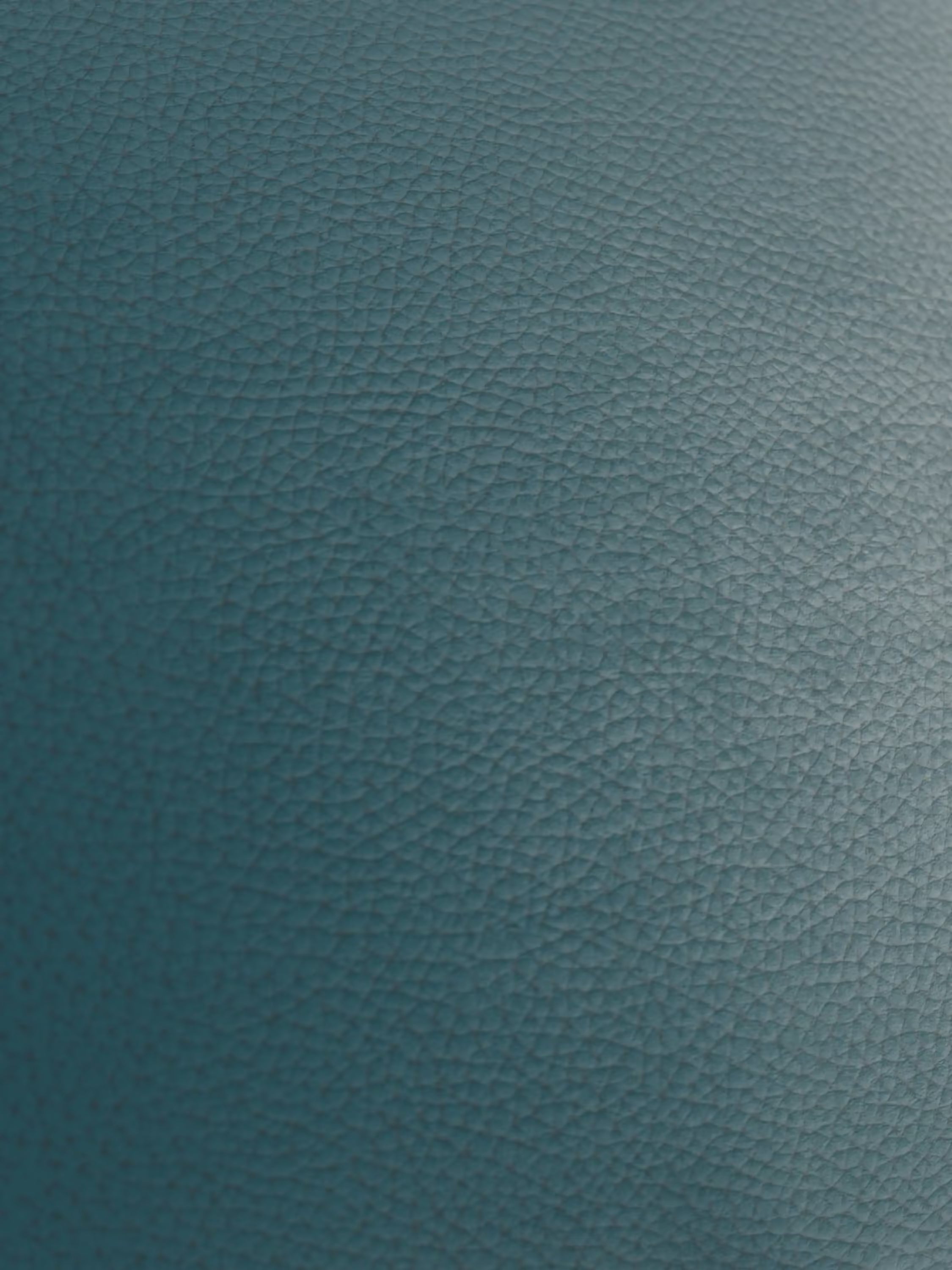 Primo piano di una superficie blu con texture, che richiama la qualità lussuosa del modello Chester – Divano Chesterfield in vera pelle spessorata a 2 e 3 posti di Divani.Store. L’illuminazione accentua la grana fine e leggermente in rilievo, caratteristica della pelle martellata di alta qualità, creando ombre delicate e conferendo una lucentezza e una profondità sottili che mettono in risalto la raffinata maestria artigianale. Non sono visibili forme o oggetti distinti.
