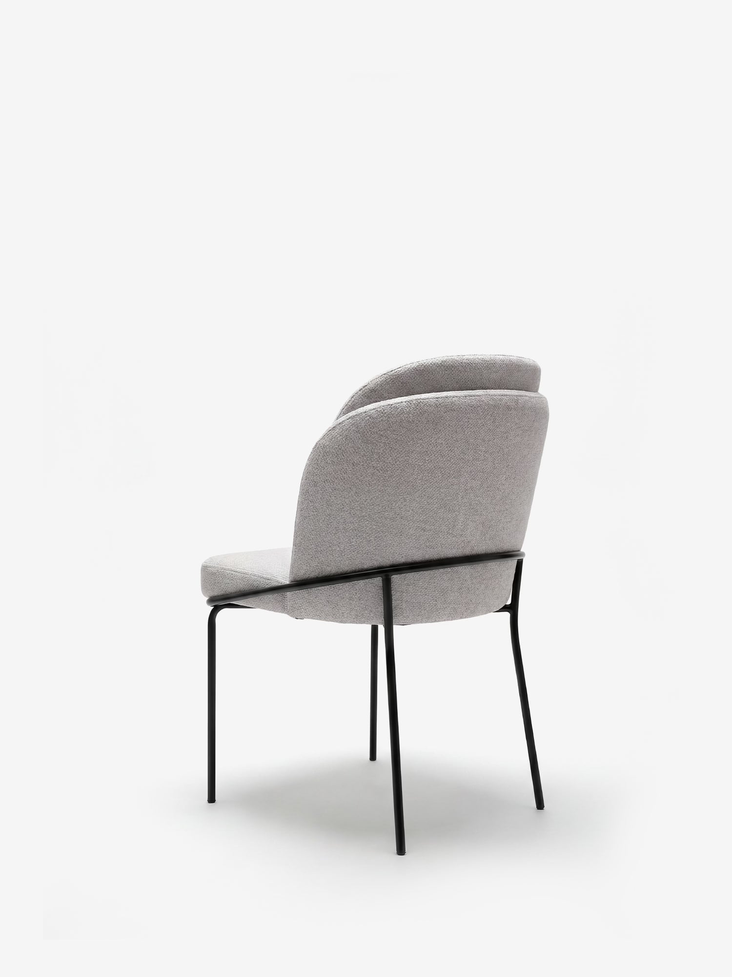 La sedia imbottita Plissè in tessuto impermeabile di Divani.Store presenta uno schienale plissettato, una seduta grigio chiaro e gambe in metallo nero. Il suo design elegante e minimalista risalta su uno sfondo bianco a tinta unita.