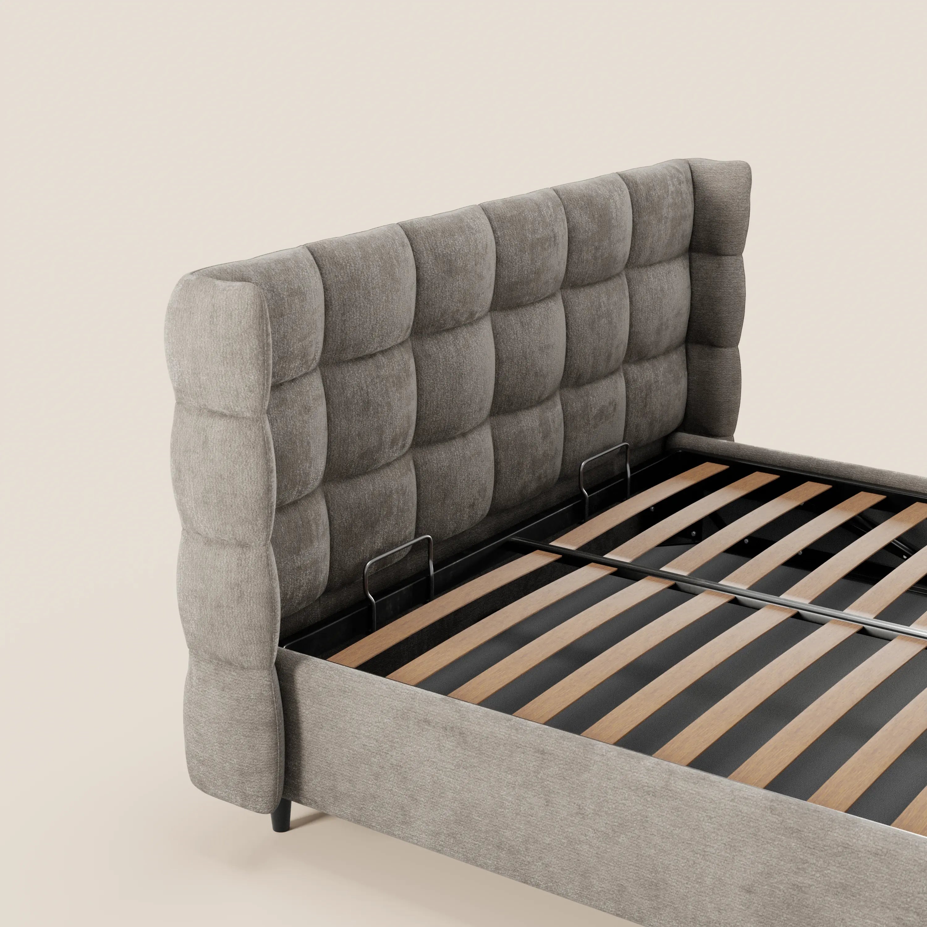 Il letto imbottito RAGNAR di Letti.store presenta una testiera capitonné avvolgente in tessuto grigio certificato Oeko-Tex®, con motivo a quadri e vano contenitore. Doghe in legno e trave metallica a vista su fondo beige, senza materasso.