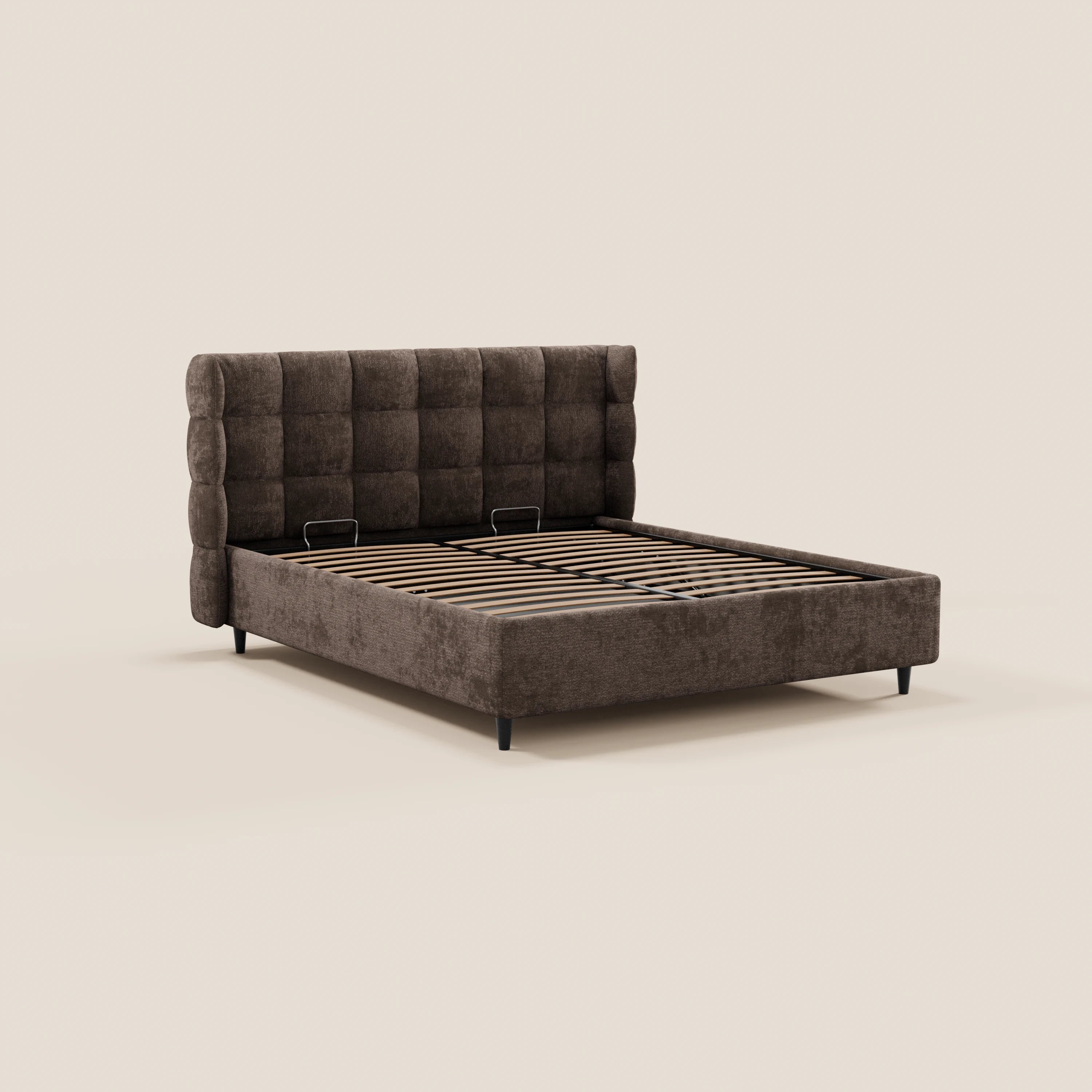 Il letto imbottito RAGNAR di Letti.store presenta una testiera avvolgente capitonné, rivestimento marrone scuro certificato Oeko-Tex®, una base coordinata con contenitore, doghe in legno e gambe corte nere. Immagine su sfondo beige; materasso non incluso.