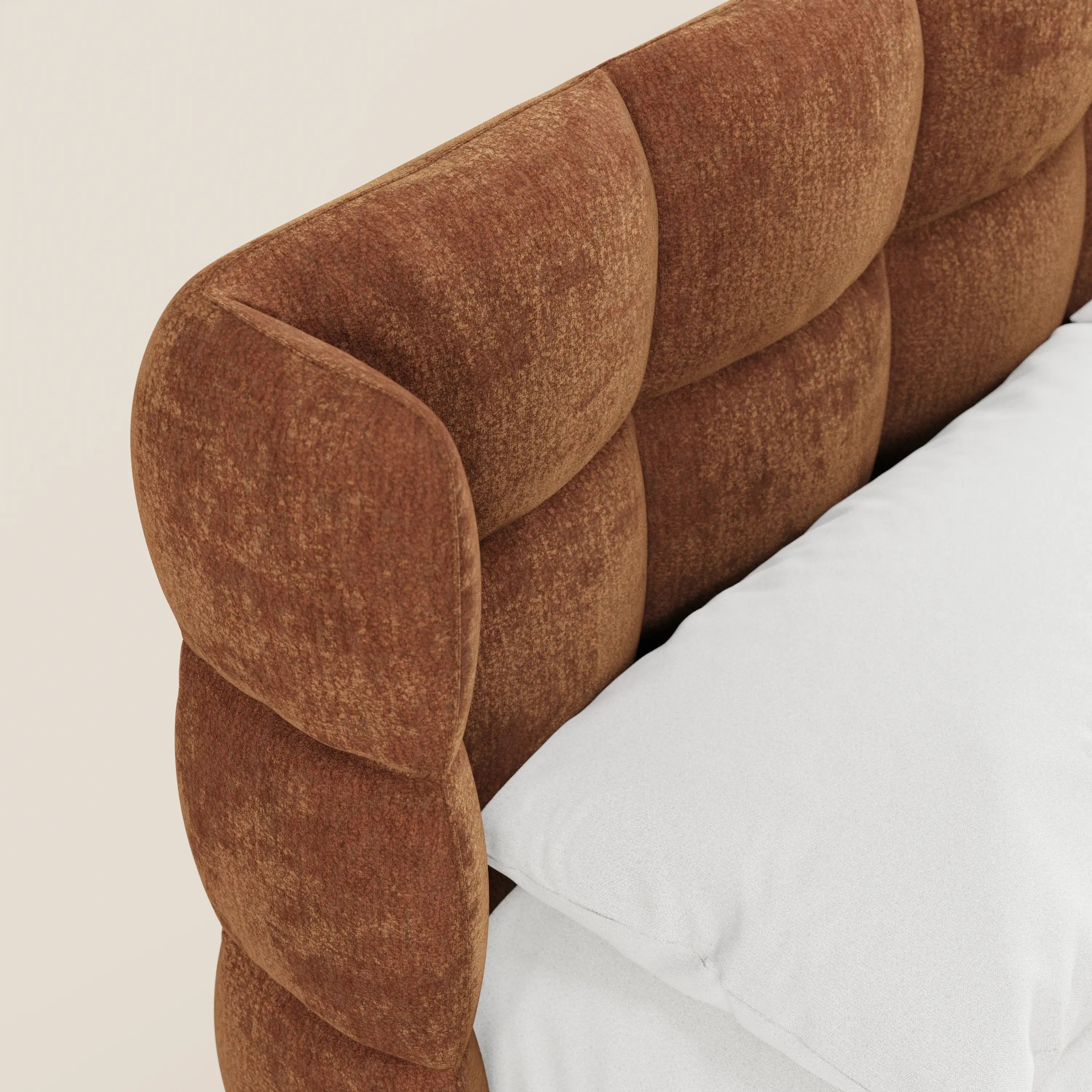 Un primo piano del letto imbottito RAGNAR di Letti.store, caratterizzato da una testiera capitonné in morbido tessuto certificato Oeko-Tex® con quadrati trapuntati. L'elegante letto è rifinito con cura con biancheria da letto bianca, che risalta su uno sfondo beige chiaro.