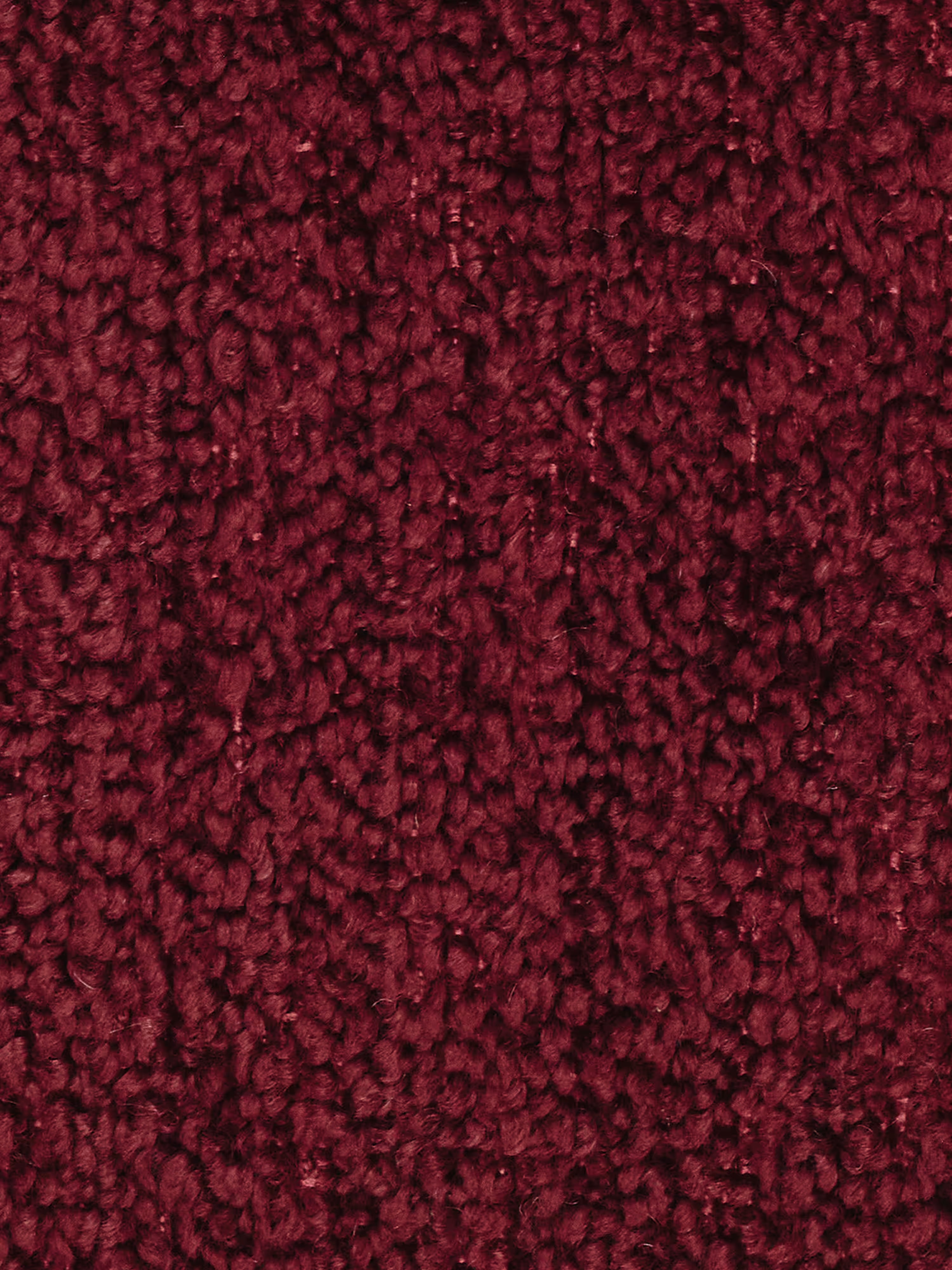 Primo piano della poltrona Mosaic modulo da 77 cm in bouclé di Divani.Store, caratterizzata da una superficie morbida e dalla trama ricca, realizzata in tessuto T21 smacchiabile color bordeaux intenso. Le fibre fitte e ad anello richiamano la raffinatezza del tessuto bouclé, creando un aspetto morbido e uniforme con sottili variazioni di sfumatura a seconda della direzione delle fibre. Nessun motivo o motivo visibile.