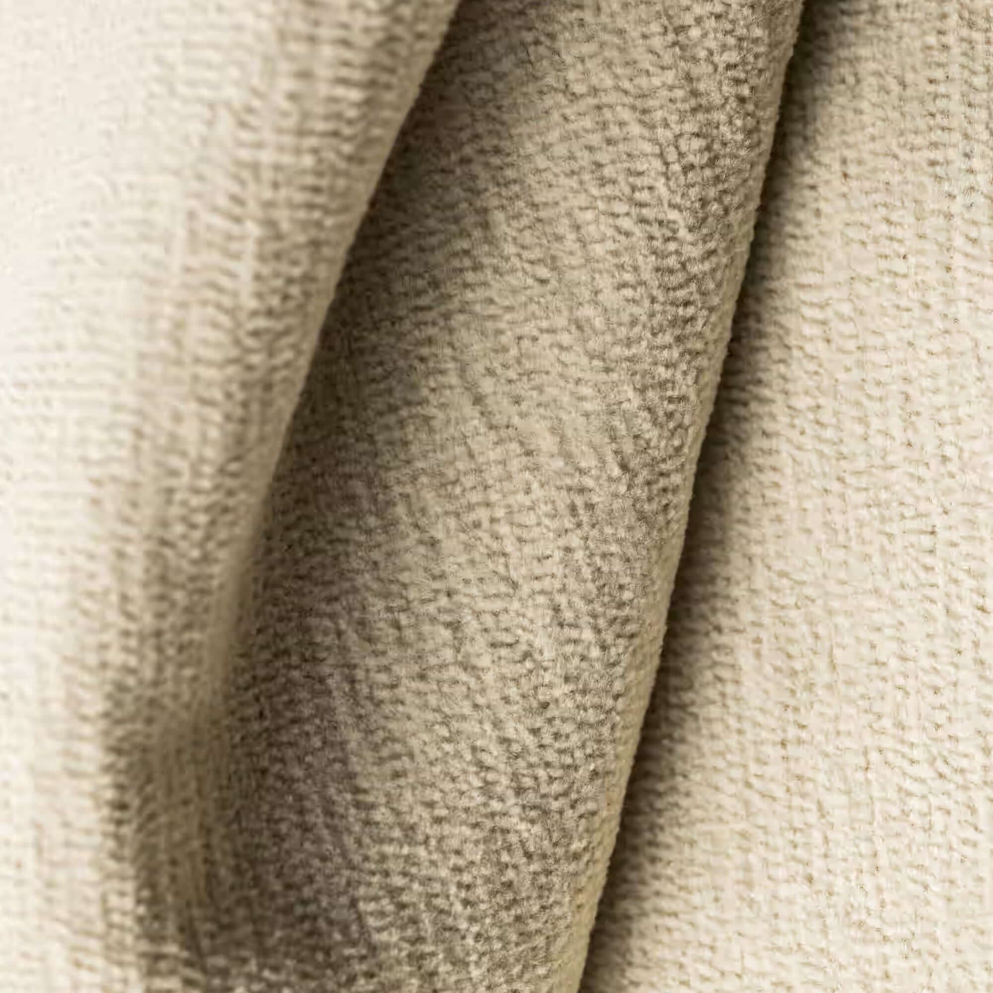 Un primo piano di T31 BOLERO di Divani.Store, un tessuto dalla mano morbida di colore beige. Il tessuto smacchiabile e impermeabile Fast Clean presenta creste e pieghe parallele che ne evidenziano la morbidezza e la profondità ad alta gamma.