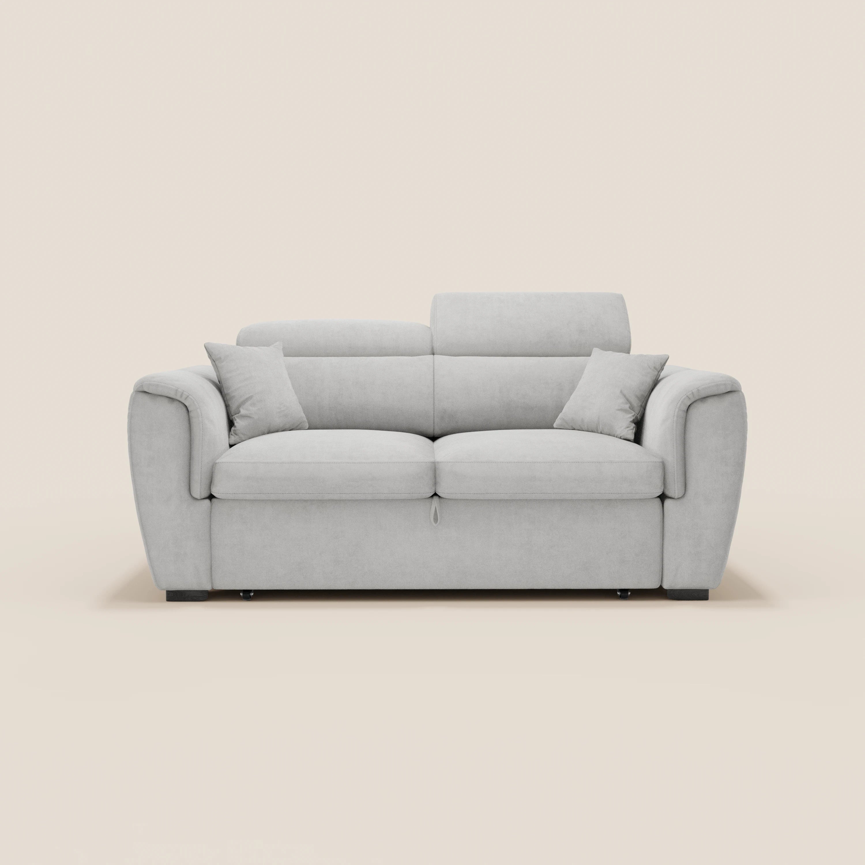 Il divano a 2 posti estraibile Titano di Divani.Store è dotato di poggiatesta reclinabili, tessuto antimacchia certificato Oeko-Tex®, ampi braccioli imbottiti, due cuscini decorativi abbinati e seduta imbottita su gambe corte nere, il tutto su uno sfondo bianco sporco a tinta unita.