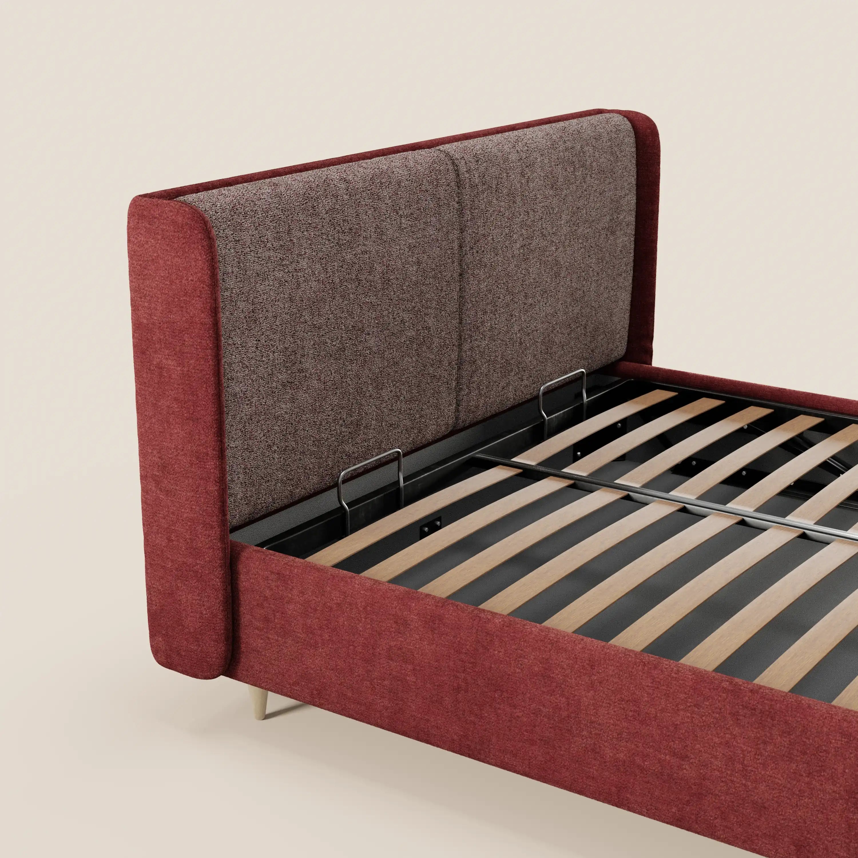 Il letto imbottito bicolore VALKIRIA di Letti.store è dotato di vano contenitore, cuscini per lo schienale e testiera curva avvolgente. Rivestito in tessuto marrone e rosso, con gambe metalliche inclinate e doghe in legno a vista. Fondo beige chiaro.