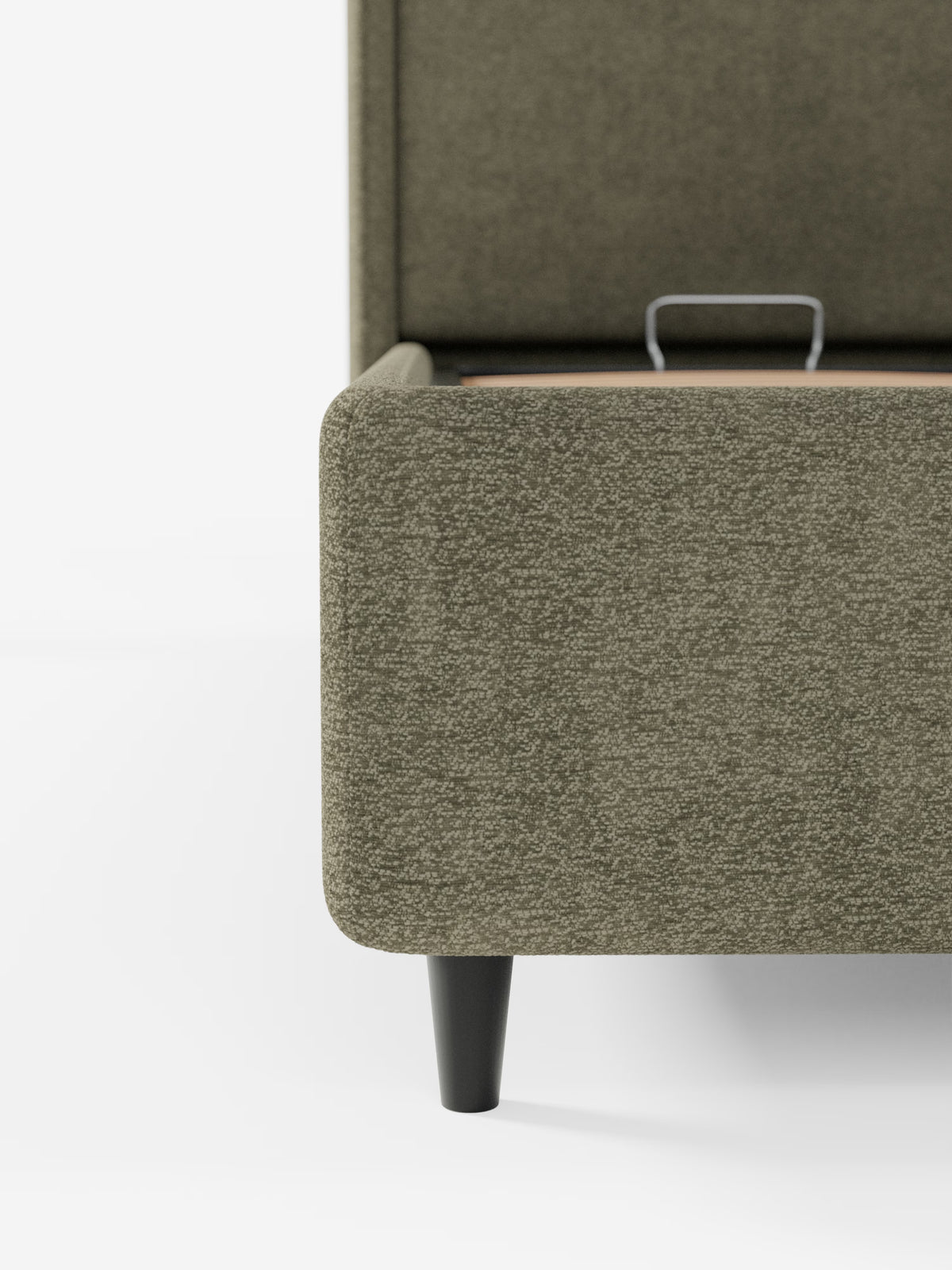 Primo piano della struttura del letto VALKIRIA di Letti.store, di colore grigio-verdastrio, con rivestimento in tessuto Oeko-Tex® e gambe corte affusolate di colore nero. L’immagine mostra una parte della testiera avvolgente con due cuscini imbottiti e una piccola maniglia in metallo all’interno del vano contenitore, caratteristica di questo pratico modello di letto. Lo sfondo bianco a tinta unita mette in risalto la trama contemporanea e la forma elegante del letto.
