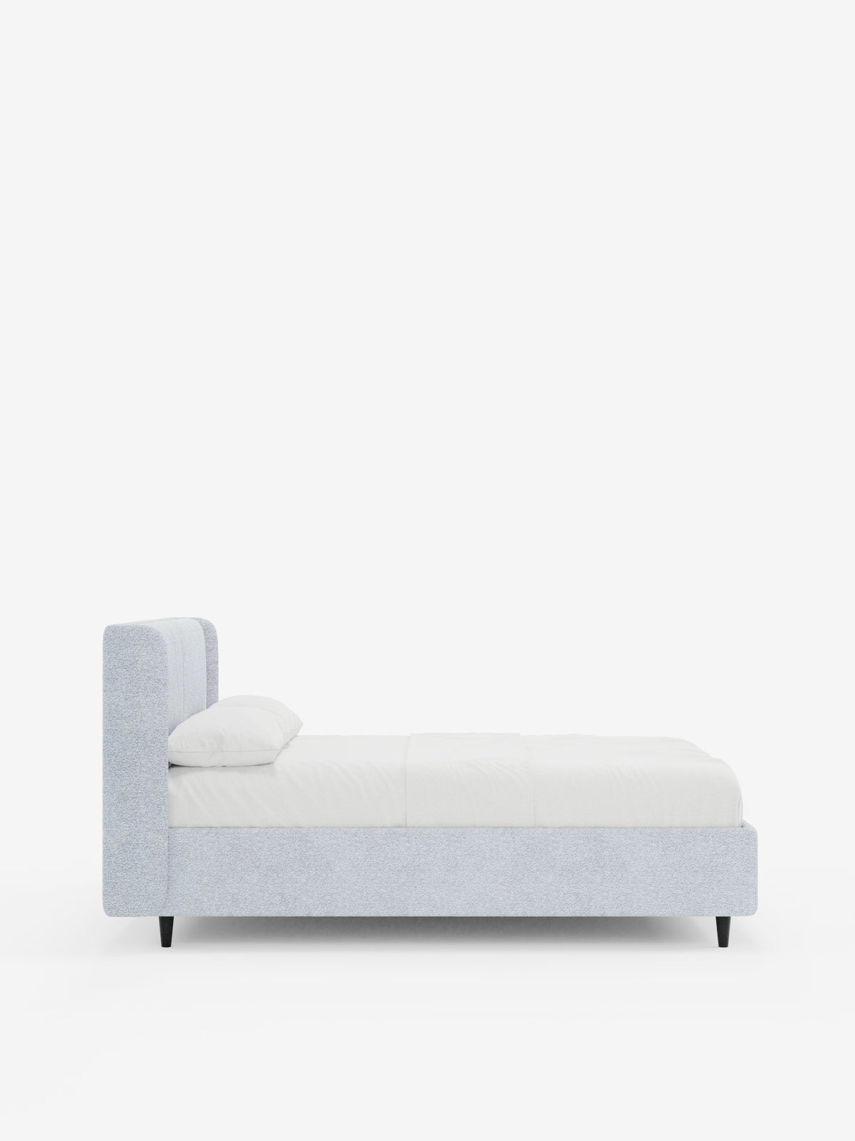 Una vista laterale del letto di design VALKIRIA con vano contenitore e testiera avvolgente di Letti.Modello in grigio chiaro moderno, caratterizzato da una testiera rettangolare con 2 cuscini imbottiti in tessuto Oeko-Tex®, biancheria da letto candida, un cuscino disposto con cura e gambe corte nere su uno sfondo bianco a tinta unita: perfetto per chi desidera un tocco di design contemporaneo nella propria camera da letto.
