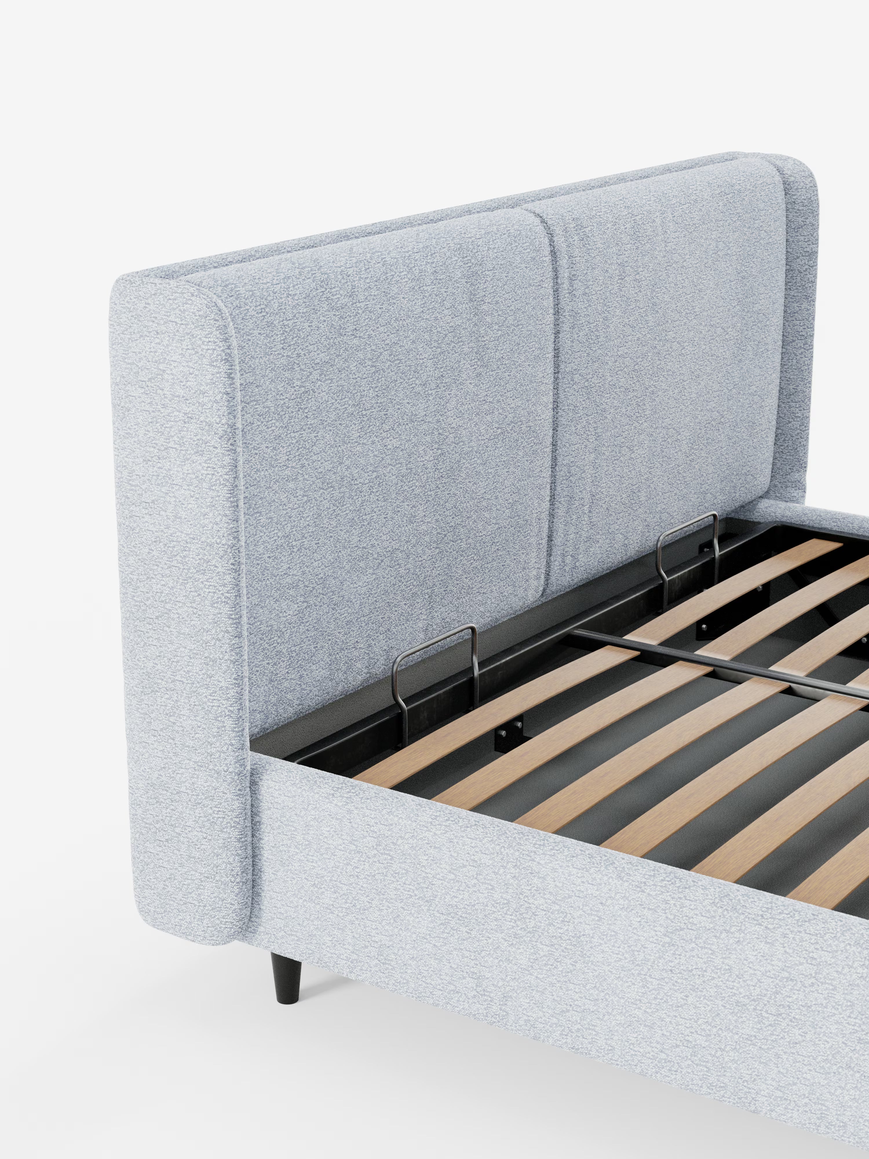 Il letto di design VALKIRIA con vano contenitore e testiera avvolgente di Letti.store presenta un rivestimento in tessuto grigio chiaro certificato Oeko-Tex®, completo di due morbidi cuscini e una testiera avvolgente. La sua base in doghe di legno è elegantemente incorniciata da metallo nero, il tutto su uno sfondo bianco a tinta unita per mettere in risalto le linee pulite del letto e il suo raffinato design contemporaneo.