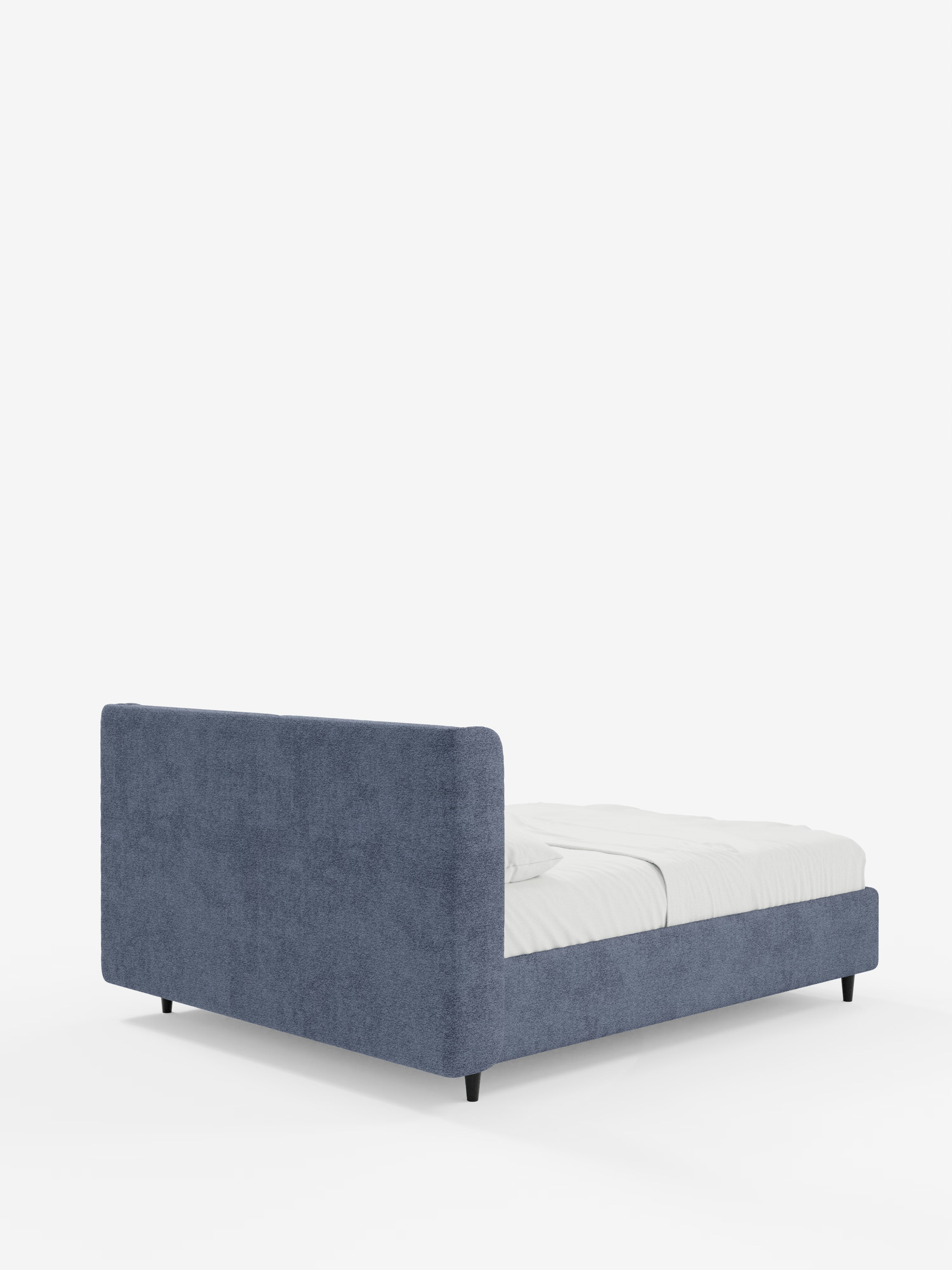 Il letto di design VALKIRIA con contenitore e testiera avvolgente di Letti.store è presentato con un rivestimento blu di grande effetto, ripreso dall’angolo posteriore sinistro. È caratterizzato da gambe corte nere e da una silhouette dal profilo ribassato, con un materasso bianco ben rifinito e la biancheria da letto adagiata sul telaio, il tutto su uno sfondo bianco a tinta unita. Le linee pulite e i contorni raffinati ne sottolineano il design contemporaneo, che coniuga comfort ed eleganza moderna. Tra