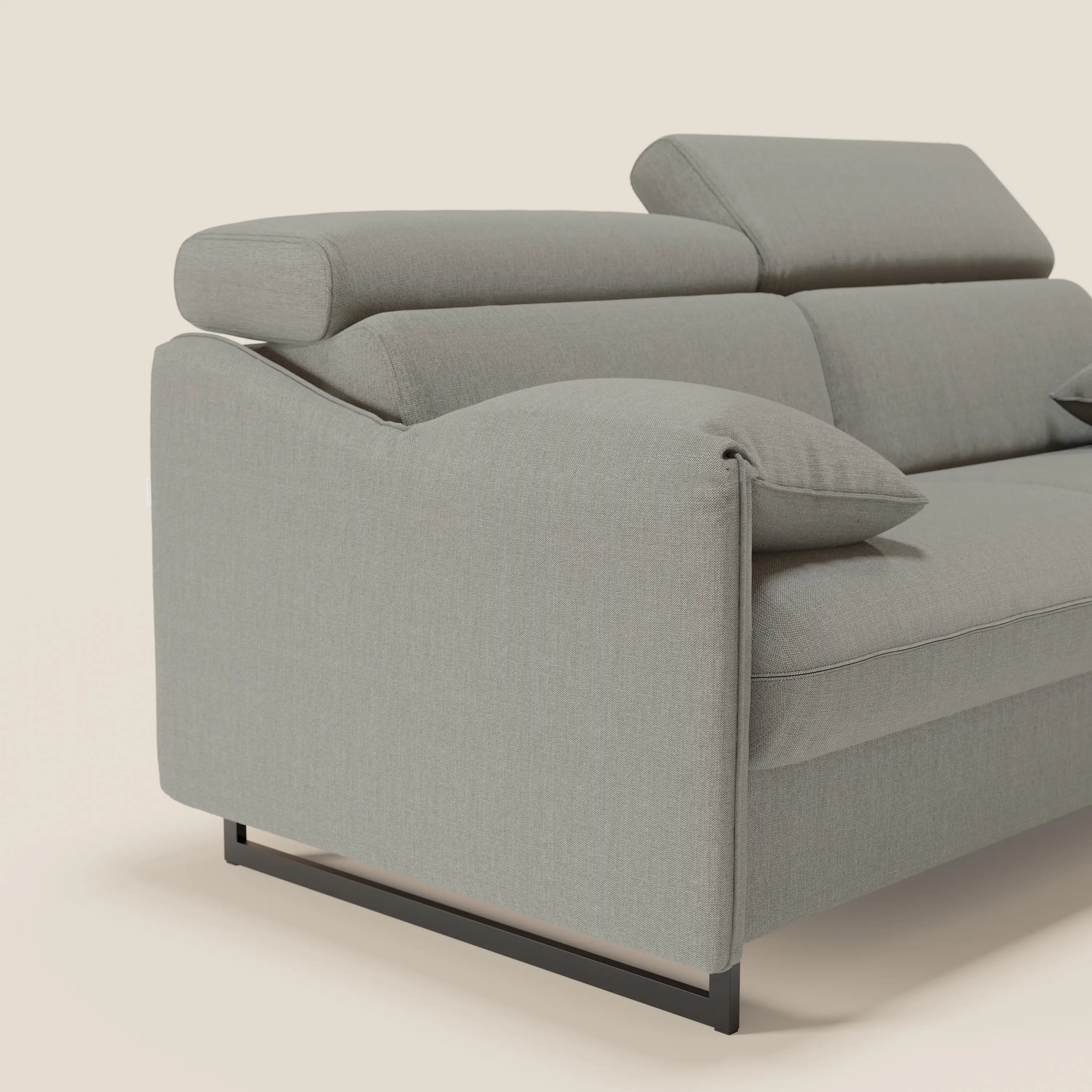 Il divano letto Violetta di Divani.Store ha un materasso H18 da 160x197 cm, poggiatesta reclinabili e braccioli mobili in tessuto impermeabile T13 grigio. La base minimal in metallo nero spicca su uno sfondo semplice.