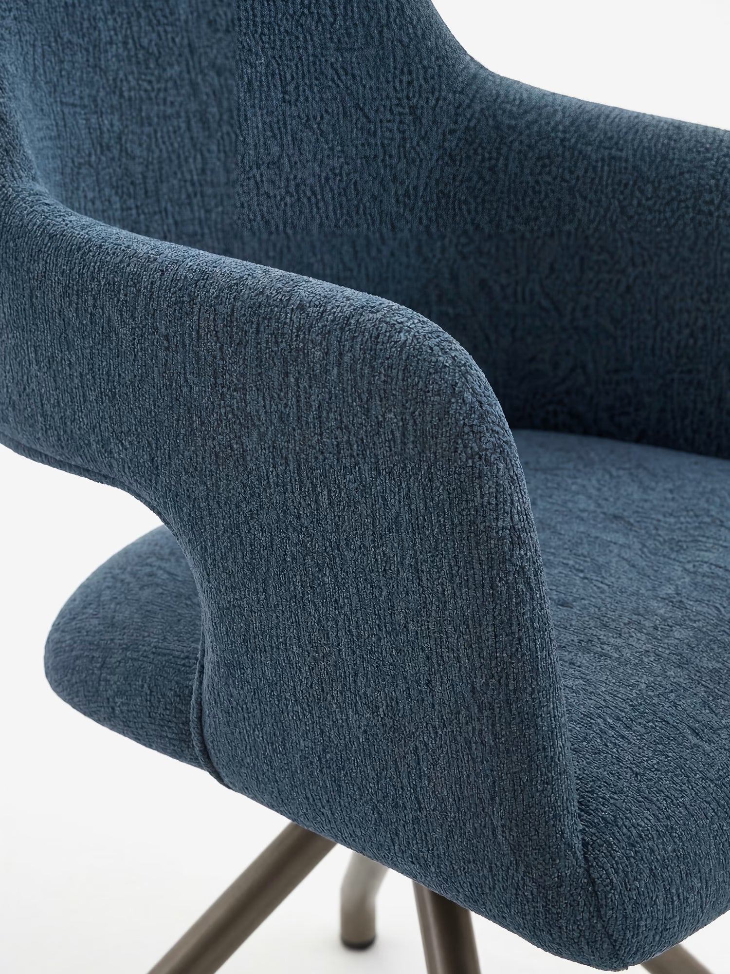 Primo piano della sedia imbottita di design Zefira di Divani.Store, caratterizzata da tessuto blu effetto cotone, braccioli ricurvi, schienale avvolgente e base in metallo color champagne, su sfondo bianco.