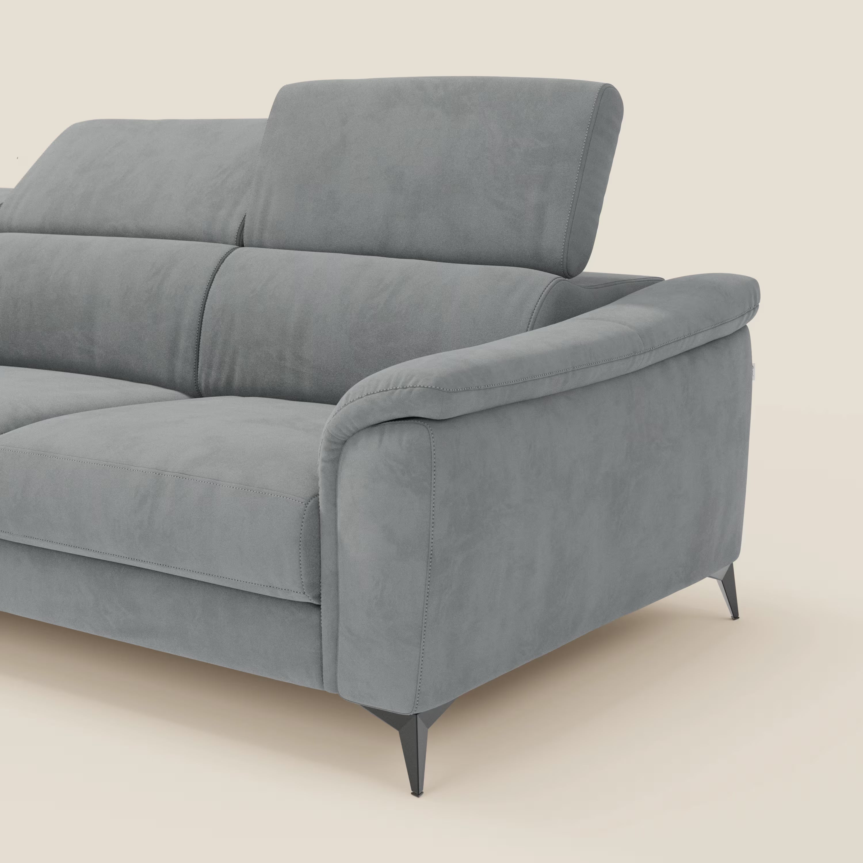 Arcos Divano con penisola di Divani.Store è caratterizzato da alte gambe nere, poggiatesta regolabili e braccioli imbottiti in microfibra impermeabile T11 grigio chiaro. Solo una parte di questo elegante divano italiano è mostrata su uno sfondo bianco sporco.