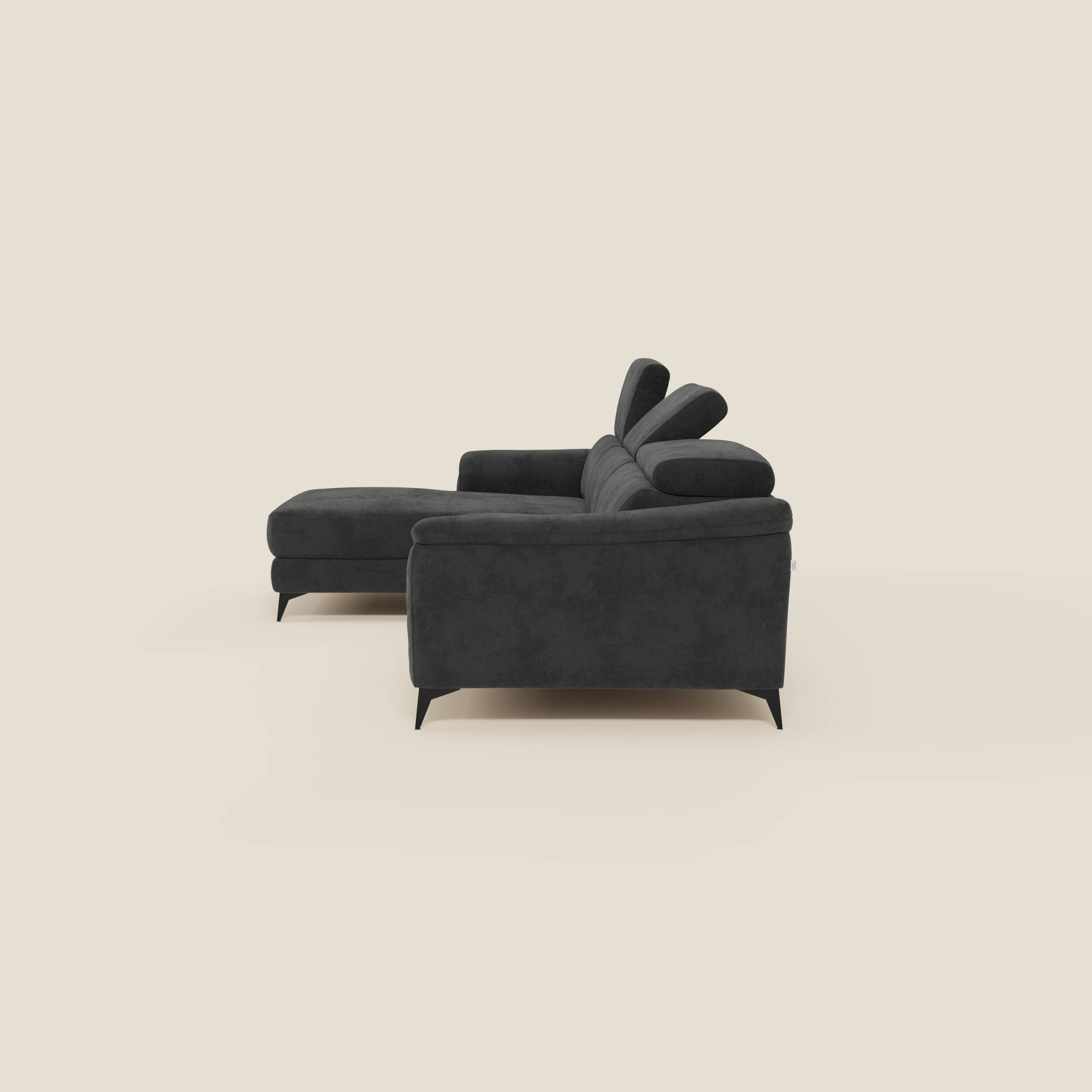 L'Arcos Divano con penisola di Divani.Store, in microfibra impermeabile T11 nero, è caratterizzato da gambe alte e poggiatesta reclinabili per un look elegante e contemporaneo su uno sfondo beige chiaro.