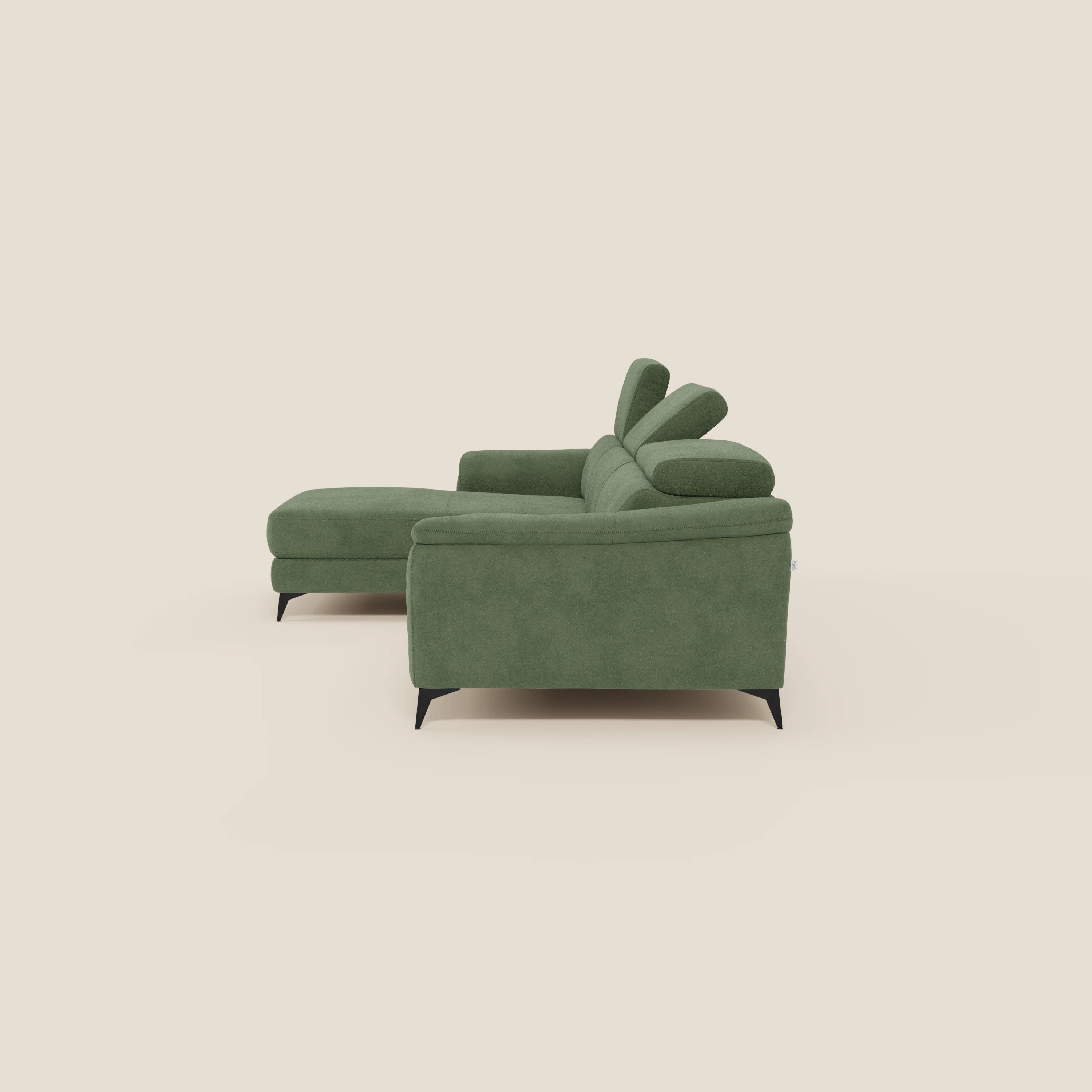 Arcos Divano con penisola di Divani.Store è caratterizzato da gambe alte, poggiatesta reclinabile e rivestimento in microfibra impermeabile verde T11, il tutto su uno sfondo beige chiaro per un tocco di moderna eleganza italiana.