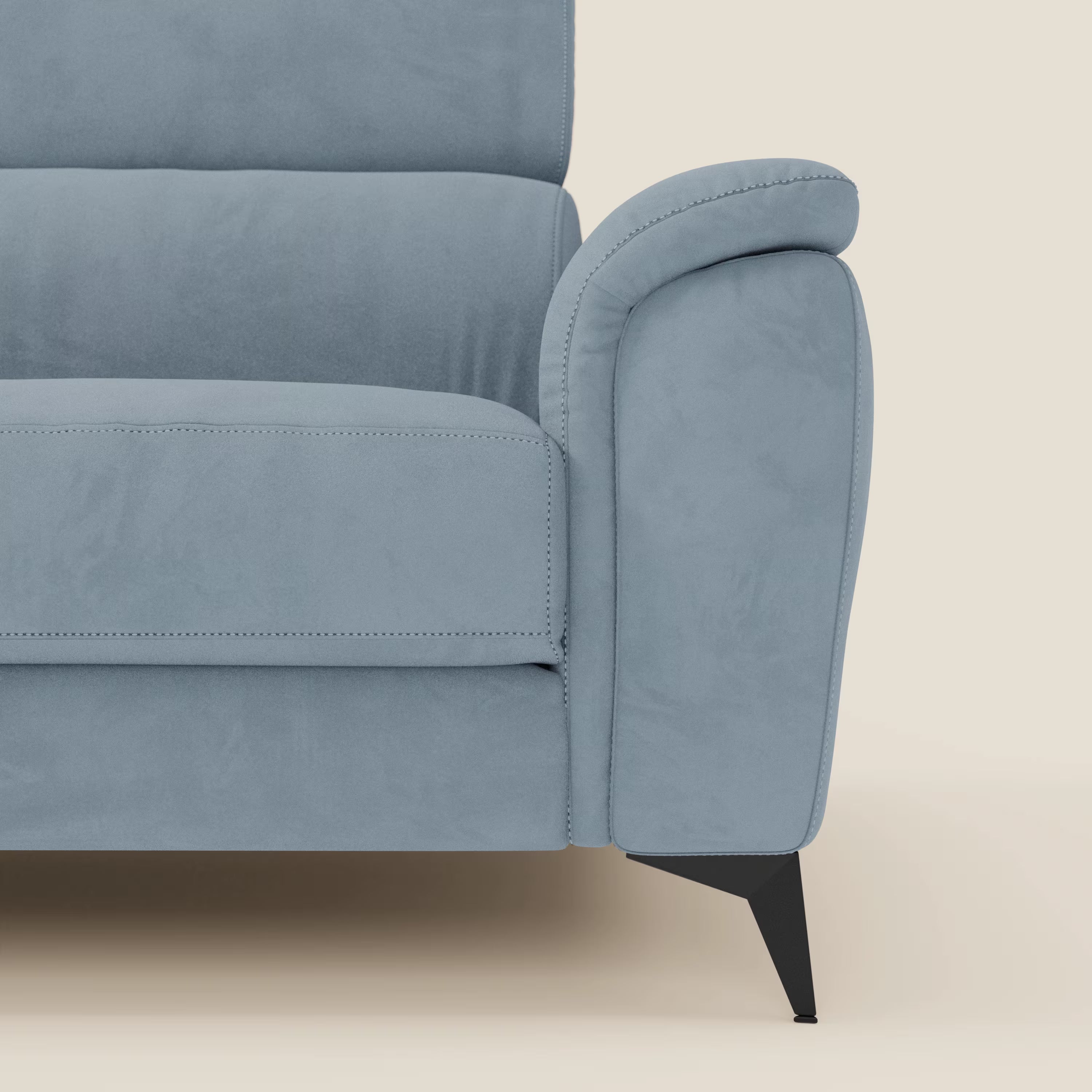 Primo piano del lato destro di Arcos Divano 3 posti di Divani.Store in microfibra T11 carta da zucchero, che mostra il bracciolo imbottito, i cuscini dello schienale, le alte gambe in metallo nero e lo sfondo color crema. È visibile solo una parte.