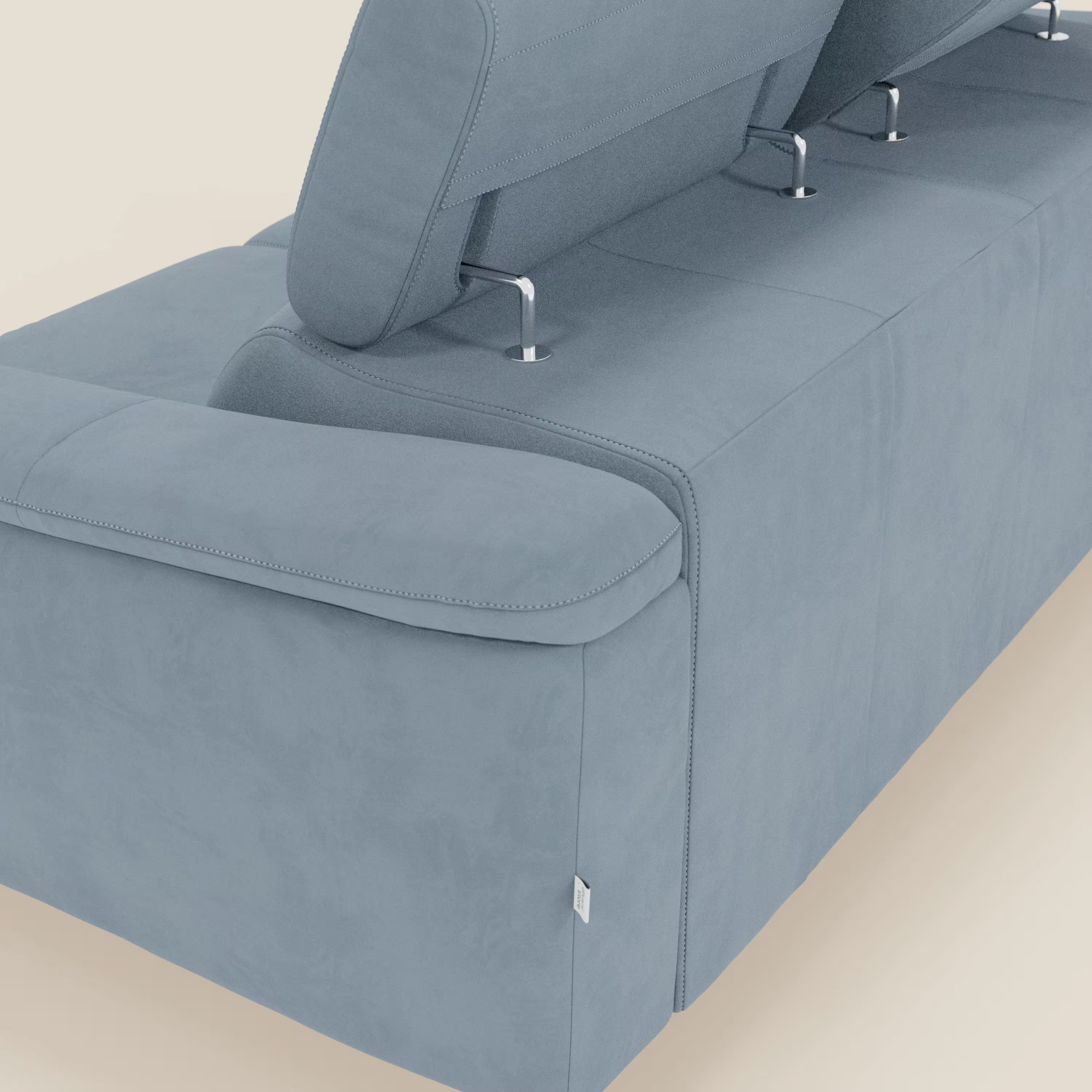 Un primo piano di Arcos Divano 3 posti di Divani.Store, con gambe alte e poggiatesta regolabili in microfibra impermeabile T11 carta da zucchero, mostra un rivestimento morbido con cuciture a vista e un'etichetta laterale in tessuto su uno sfondo a tinta unita.