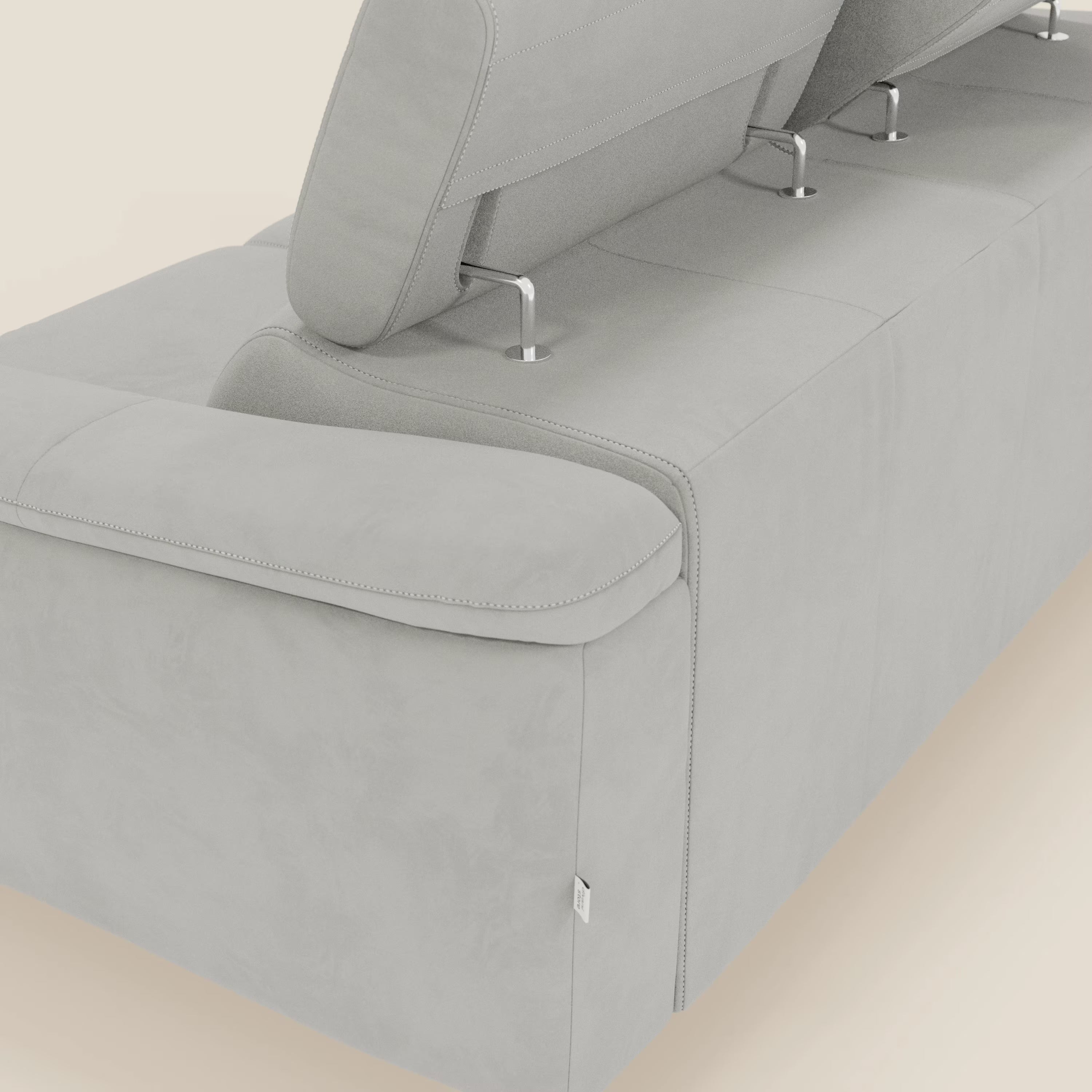 Un primo piano di Arcos Divano 3 posti di Divani.Store in microfibra impermeabile T11 grigio chiaro mostra poggiatesta regolabili con aste in metallo, cuciture a vista e gambe alte, il tutto su un elegante pavimento chiaro.