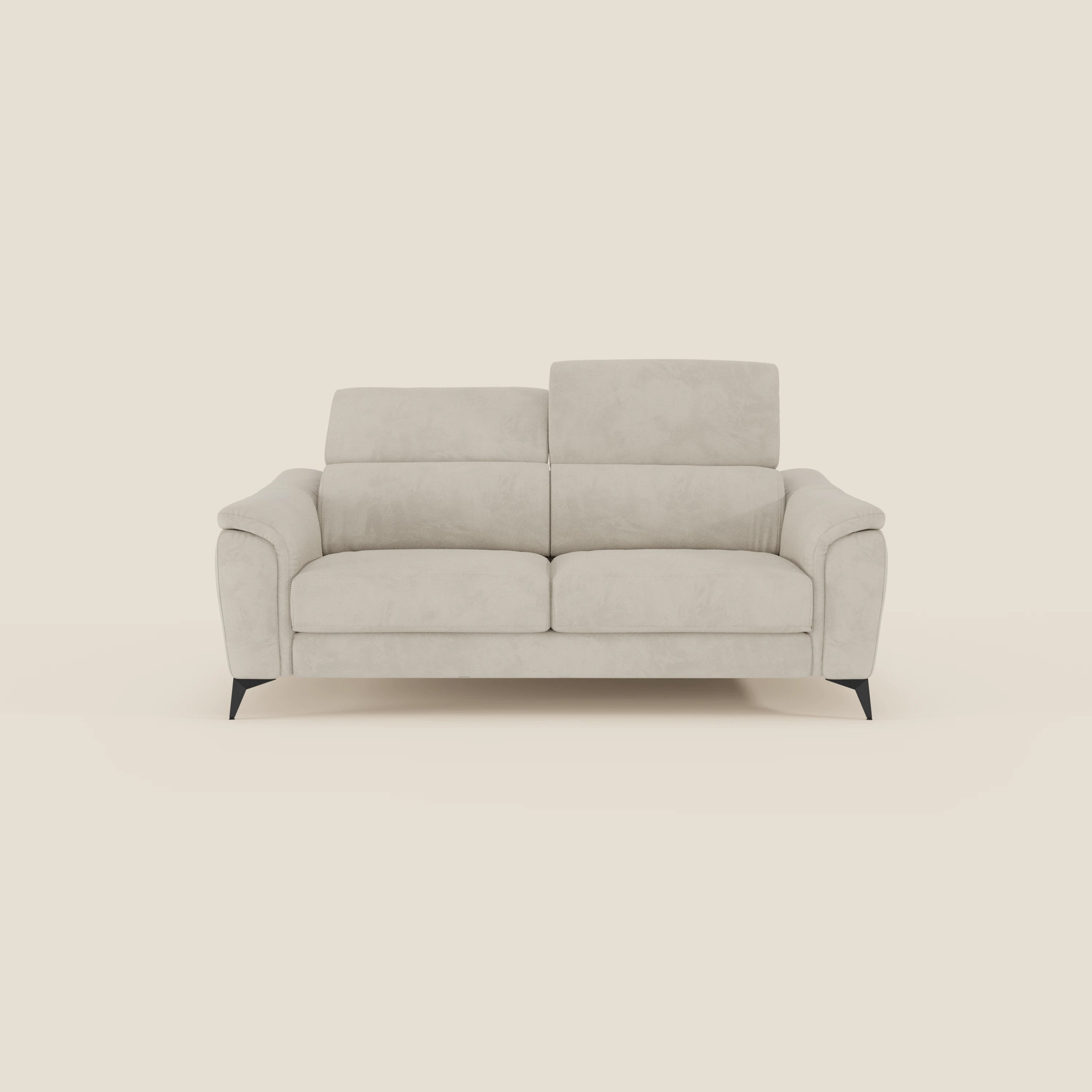 Arcos Divano 3 posti di Divani.Store è caratterizzato da gambe alte, poggiatesta regolabili e rivestimento in microfibra impermeabile T11 panna. Questo moderno divano di colore beige chiaro è inserito in un semplice sfondo color crema.