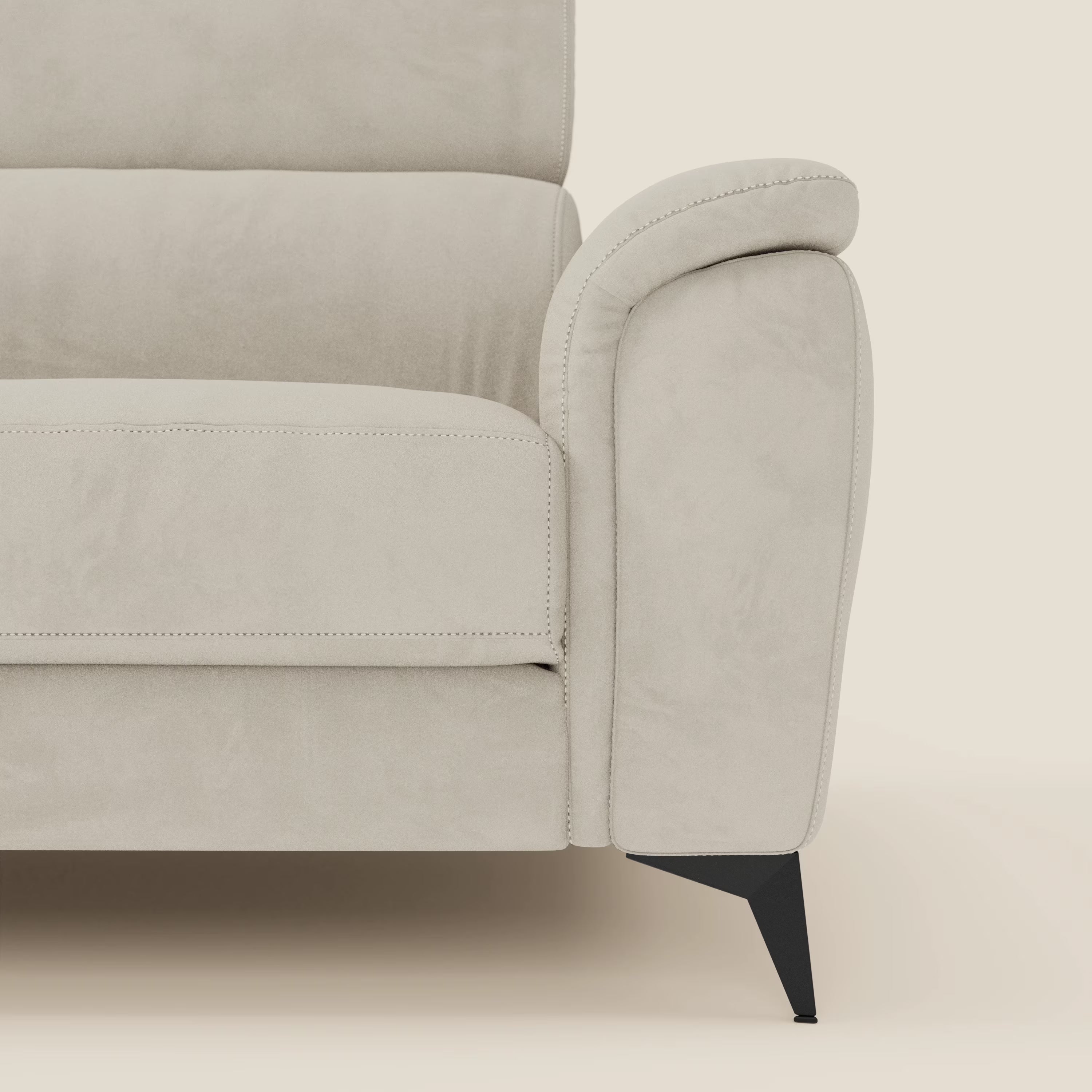 Primo piano del lato destro di Arcos Divano 3 posti di Divani.Store, con poggiatesta reclinabile, gambe alte in metallo nero e microfibra panna T11 impermeabile. Le cuciture sottili e lo sfondo chiaro ne esaltano lo stile elegante.