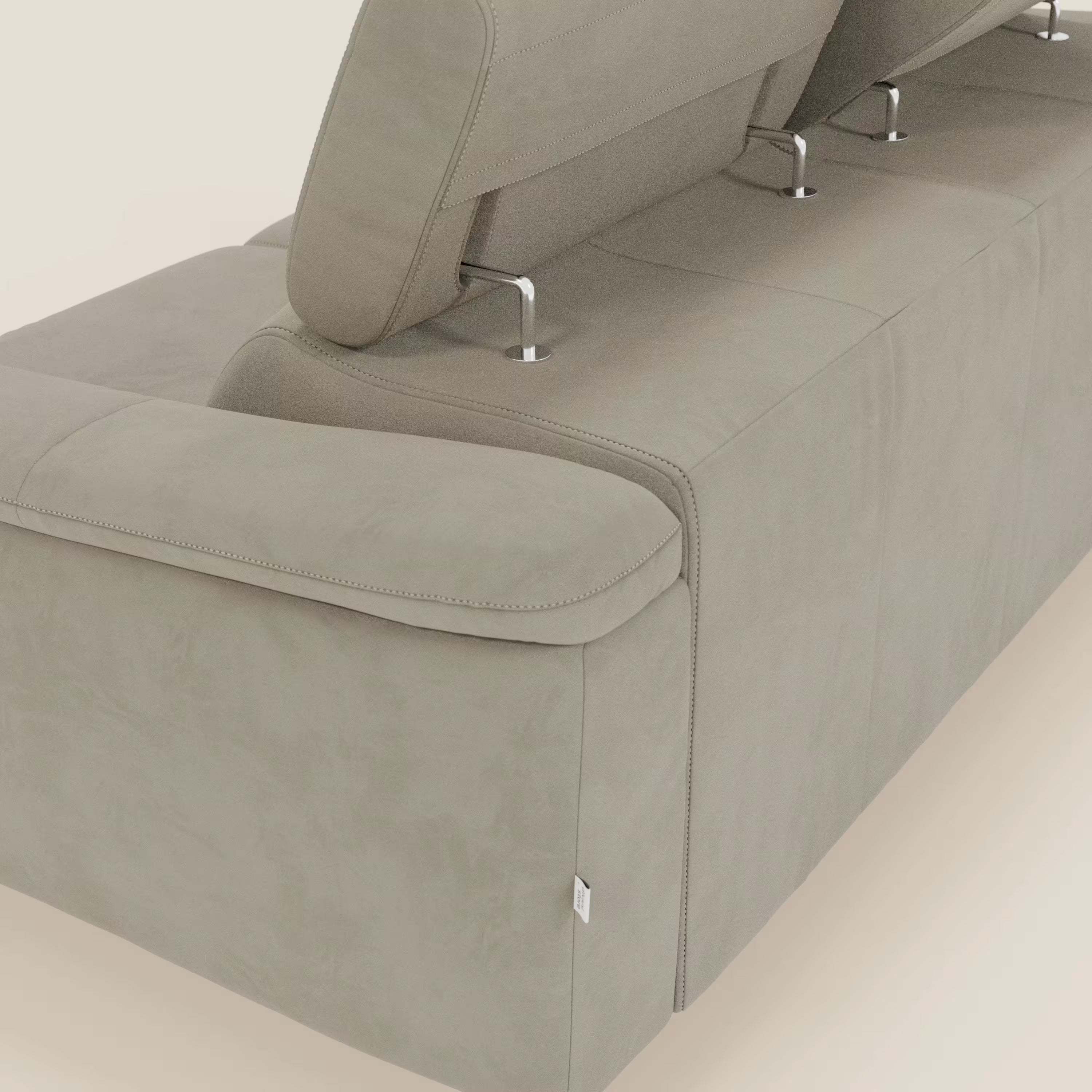 Un primo piano di Arcos Divano 3 posti di Divani.Store, con gambe alte e poggiatesta reclinabili in microfibra tortora impermeabile T11, mostra le sue eleganti cuciture e la sua texture su uno sfondo semplice.