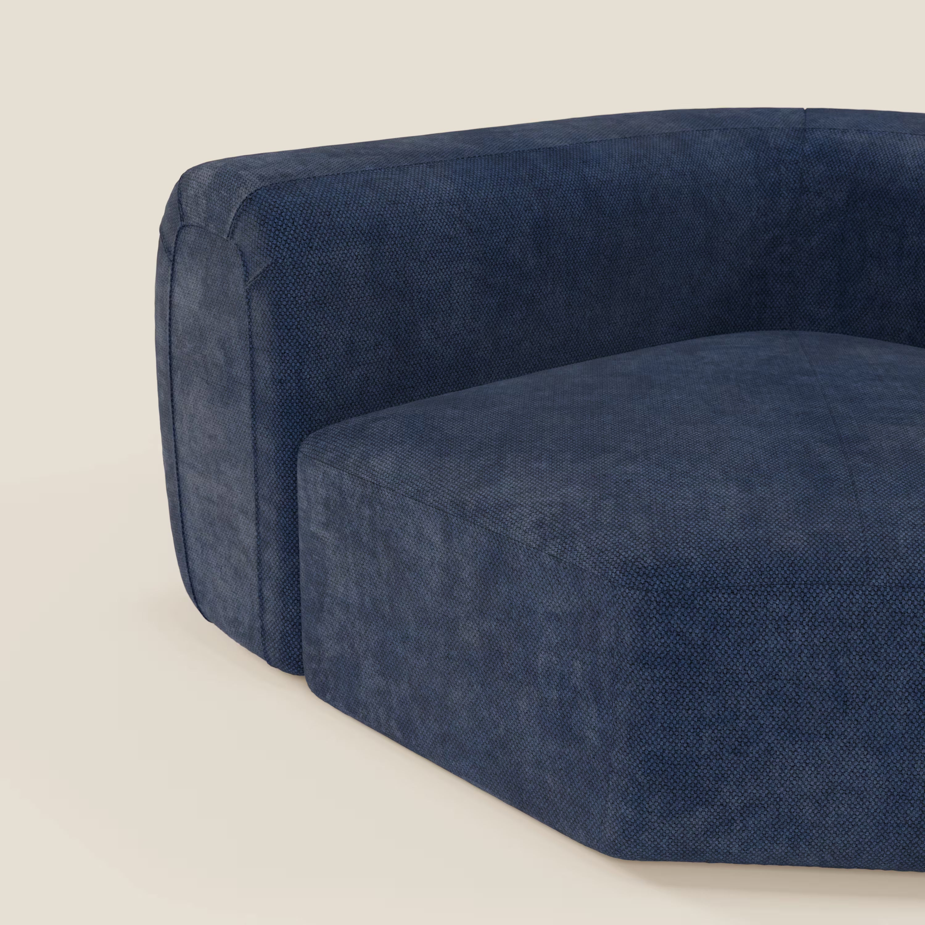 Primo piano del BonBon Modulo angolare - Divano modulare componibile GF edition blu navy di Divani.Store, che mostra il suo tessuto strutturato blu intenso, le linee pulite, i bordi morbidi e la silhouette bassa e squadrata su uno sfondo beige chiaro.