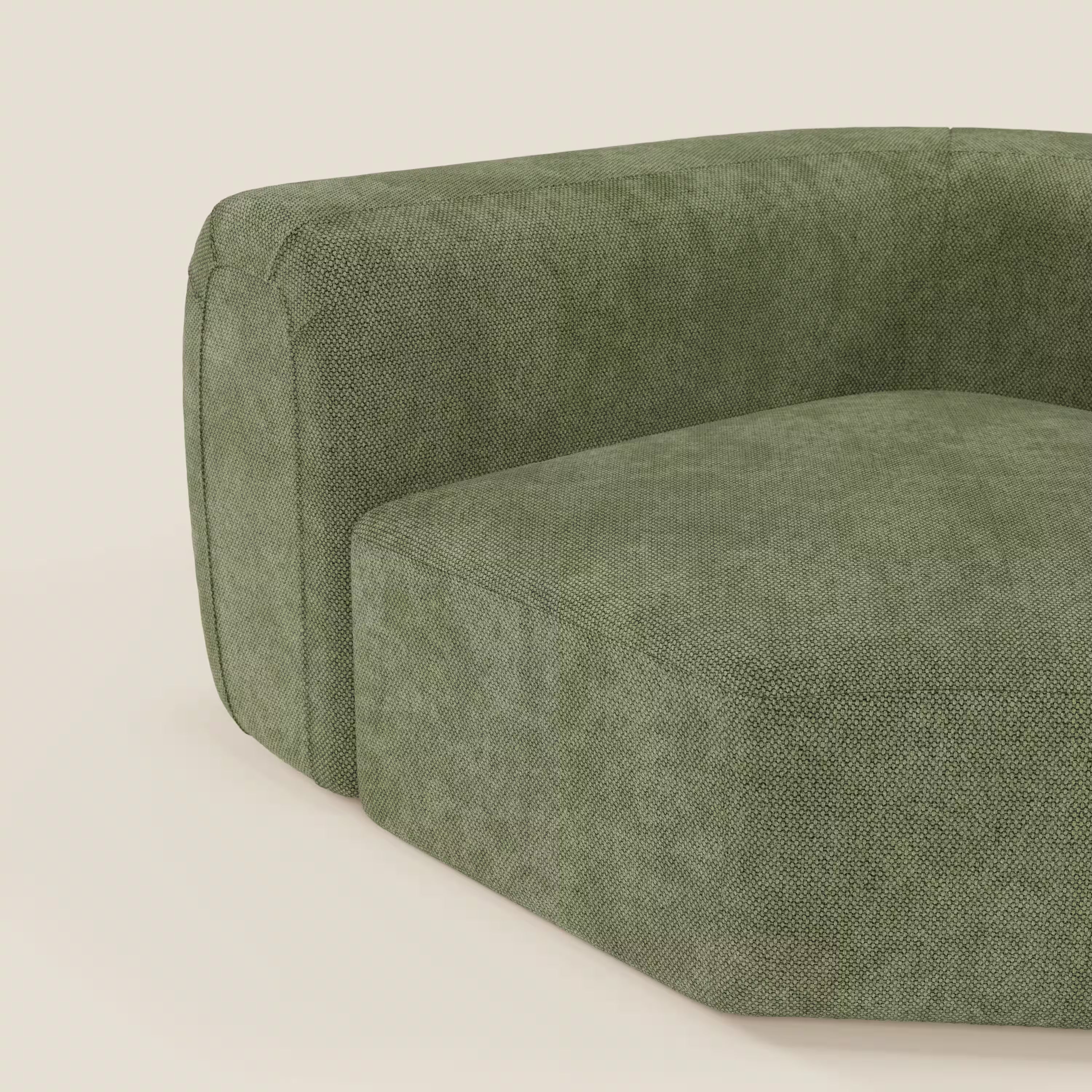 Un primo piano del BonBon Modulo angolare - Divano componibile GF edition verde muschio di Divani.Store, che mostra gli spigoli arrotondati e il rivestimento verde testurizzato su uno sfondo chiaro, con solo l'angolo e parte della seduta e dello schienale visibili.