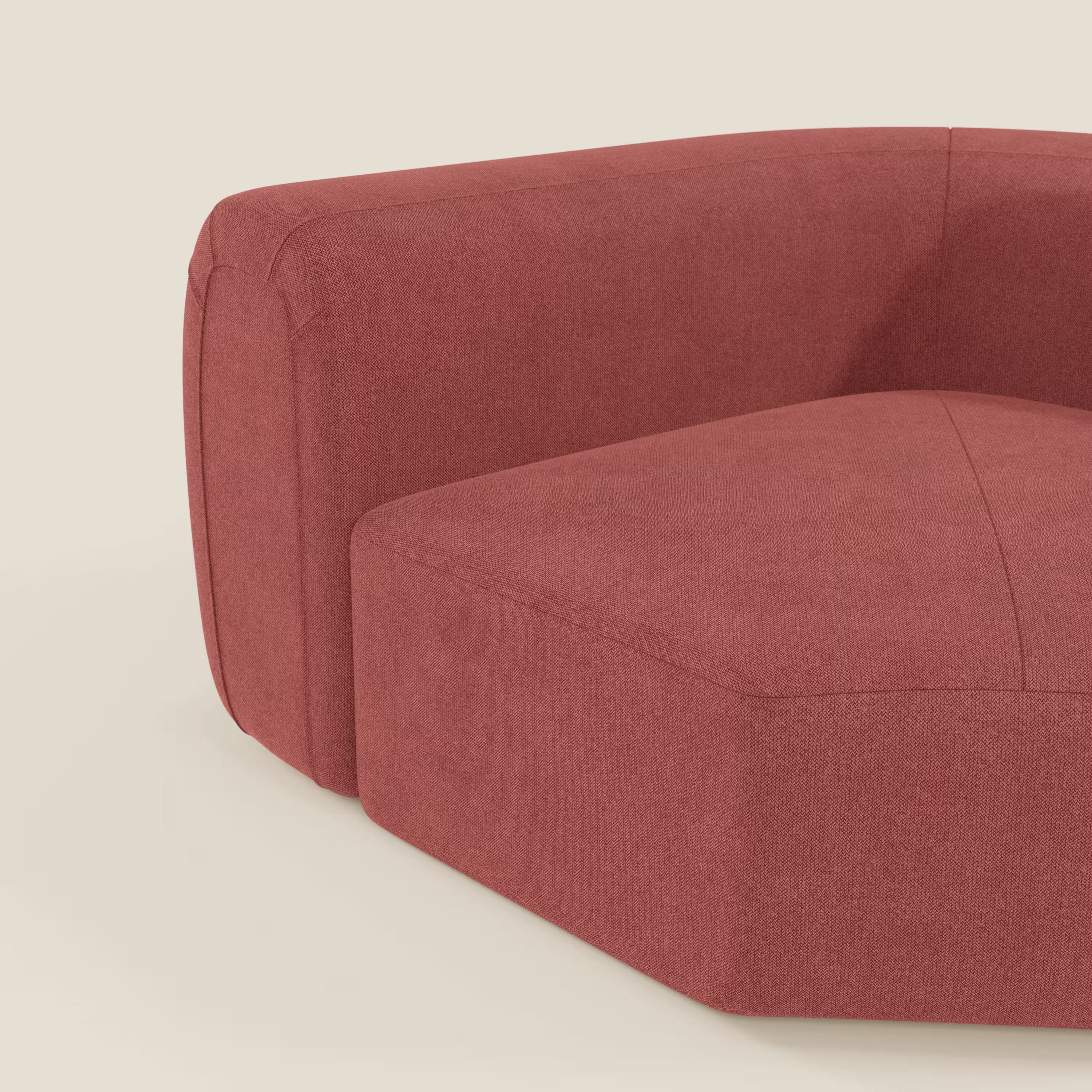 Un primo piano di Bonbon Modulo angolare di Divani.Store, un moderno divano componibile in tessuto smacchiabile T23 rosso ciliegia, mostra le linee pulite, l'ampio bracciolo e il rivestimento strutturato su uno sfondo bianco sporco.