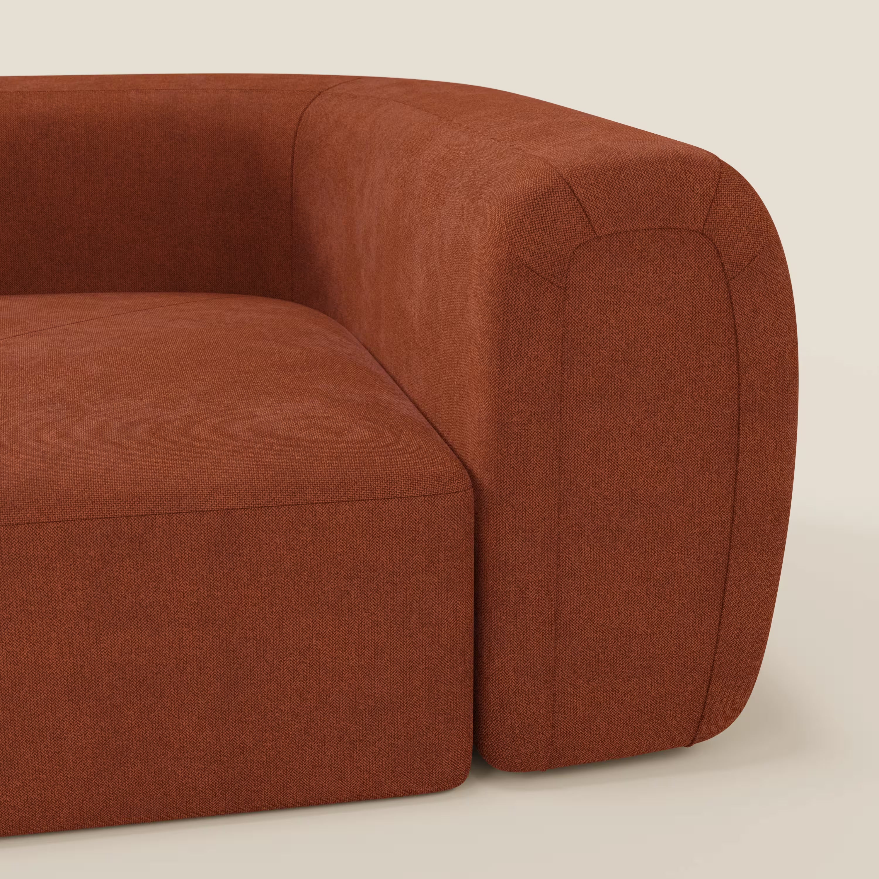 Primo piano di Bonbon Modulo angolare di Divani.Store, un moderno divano componibile in tessuto antimacchia T23 ruggine con bracciolo spesso e arrotondato, cuscino di seduta in tessuto morbido e imbottito su uno sfondo neutro.