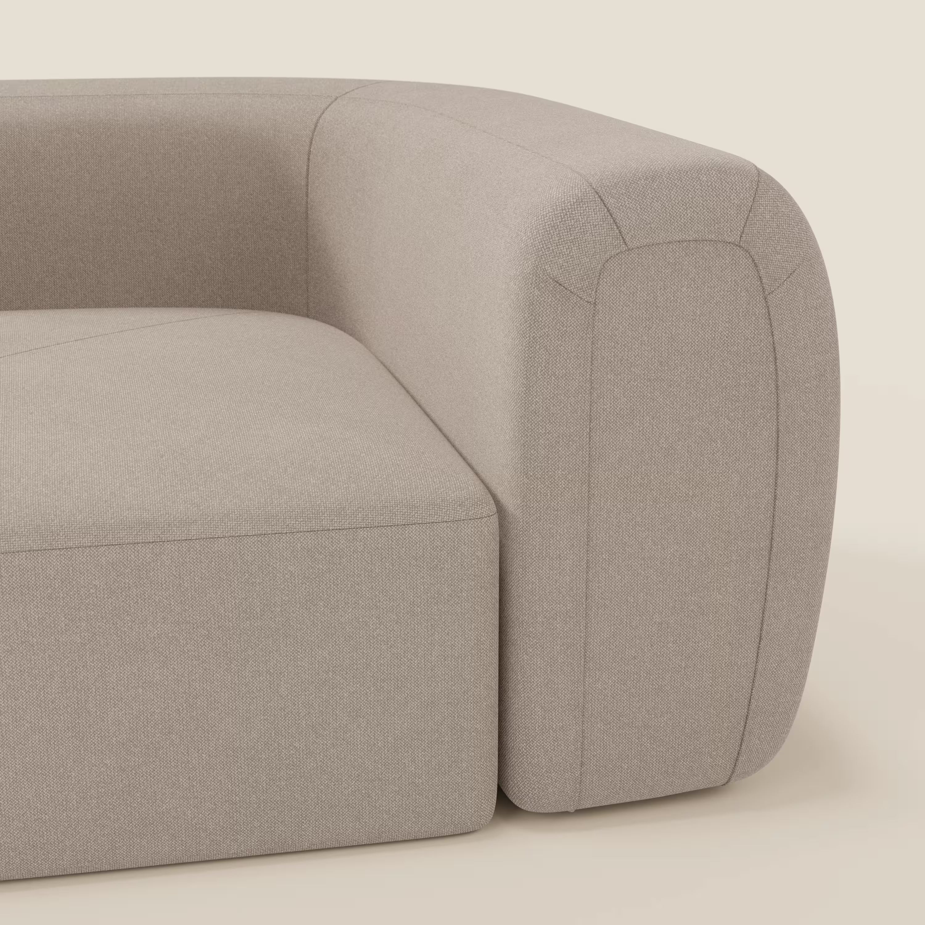 Primo piano dell'angolo sinistro di Bonbon Modulo angolare di Divani.Store, un moderno divano componibile in tessuto smacchiabile T23 tortora, dalle linee pulite, dalla seduta spessa, con bracciolo e schienale arrotondati su uno sfondo chiaro.