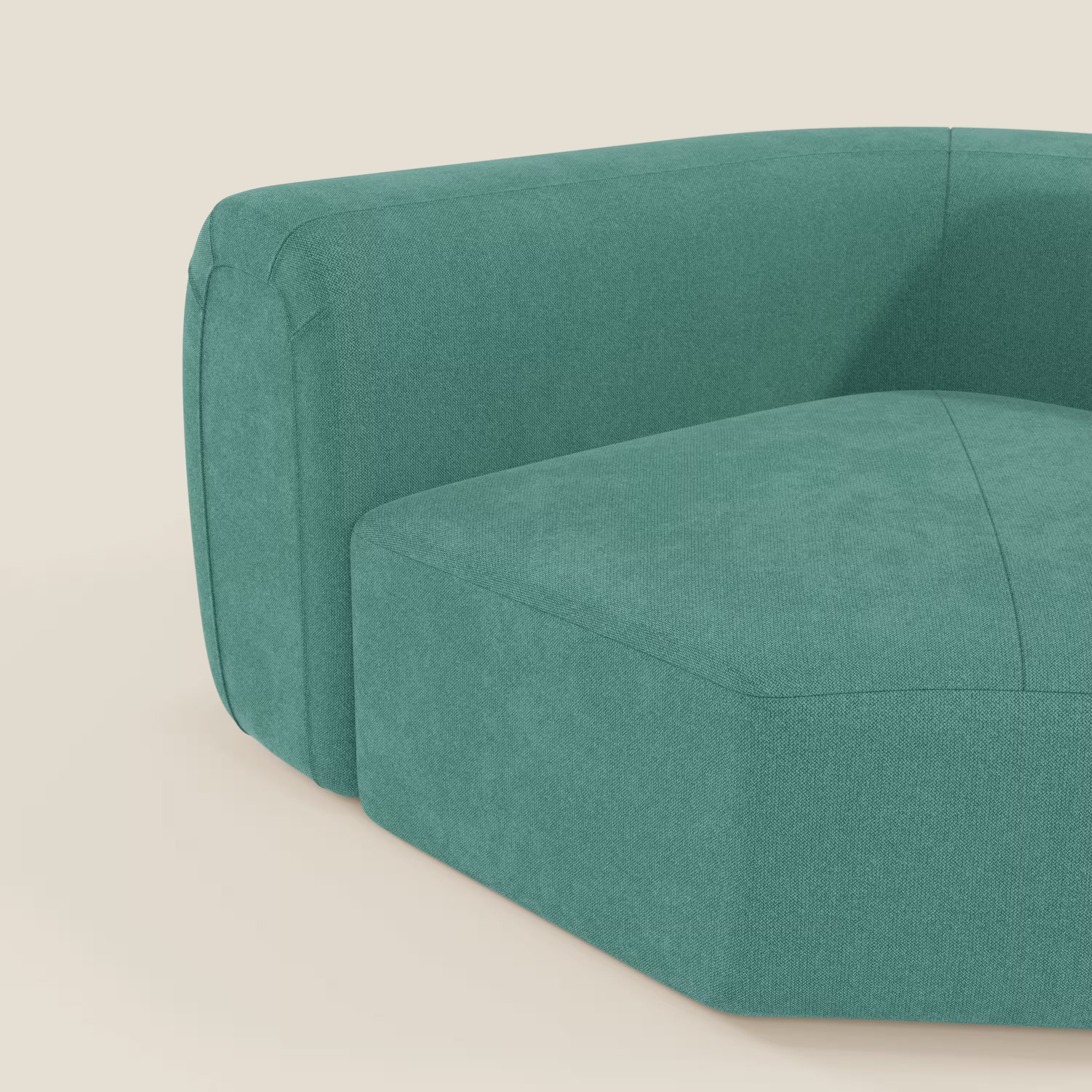 Primo piano di Bonbon modulo angolare di Divani.Store, un moderno divano in tessuto antimacchia verde acqua T23 dal design curvo e squadrato. Sullo sfondo beige chiaro sono visibili solo la parte inferiore e il bracciolo sinistro.