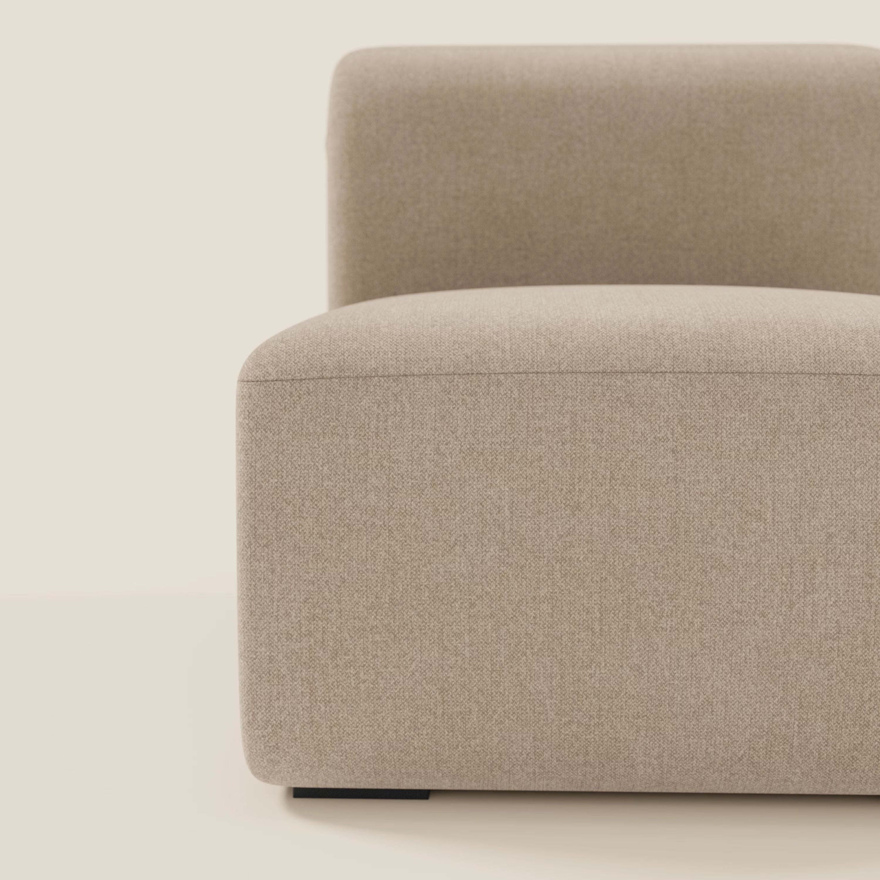 Primo piano di BonBon modulo centrale 70 cm di Divani.Store, un modulo imbottito antimacchia beige dalle linee pulite, che mostra il bracciolo sinistro, il cuscino di seduta e lo schienale su piccoli piedini neri su uno sfondo chiaro.