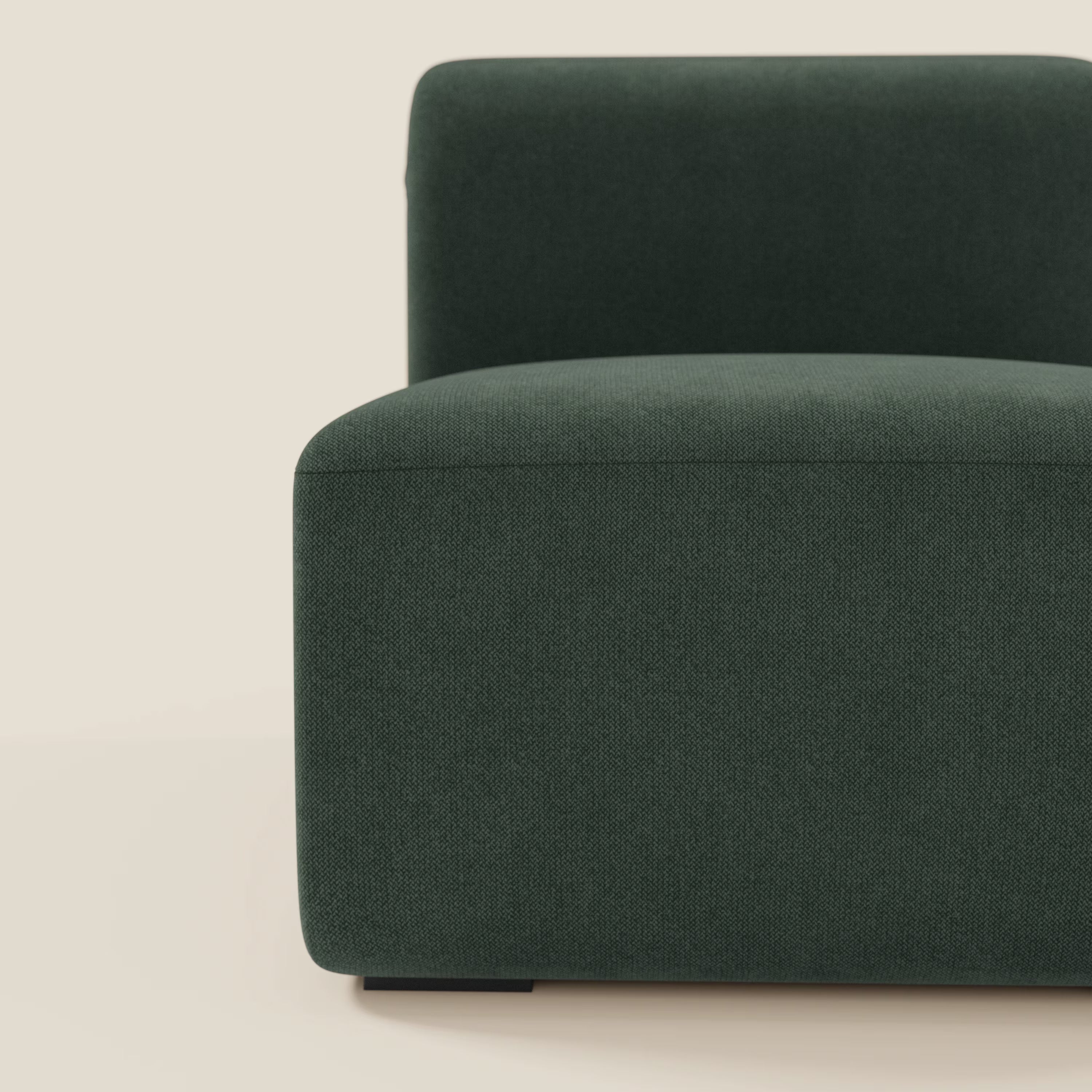 Primo piano di BonBon modulo centrale 70 cm di Divani.Store in tessuto lavabile verde T23, dalle linee pulite e squadrate e dal design minimalista su sfondo beige chiaro. È visibile solo il lato sinistro con parte della seduta e dello schienale.