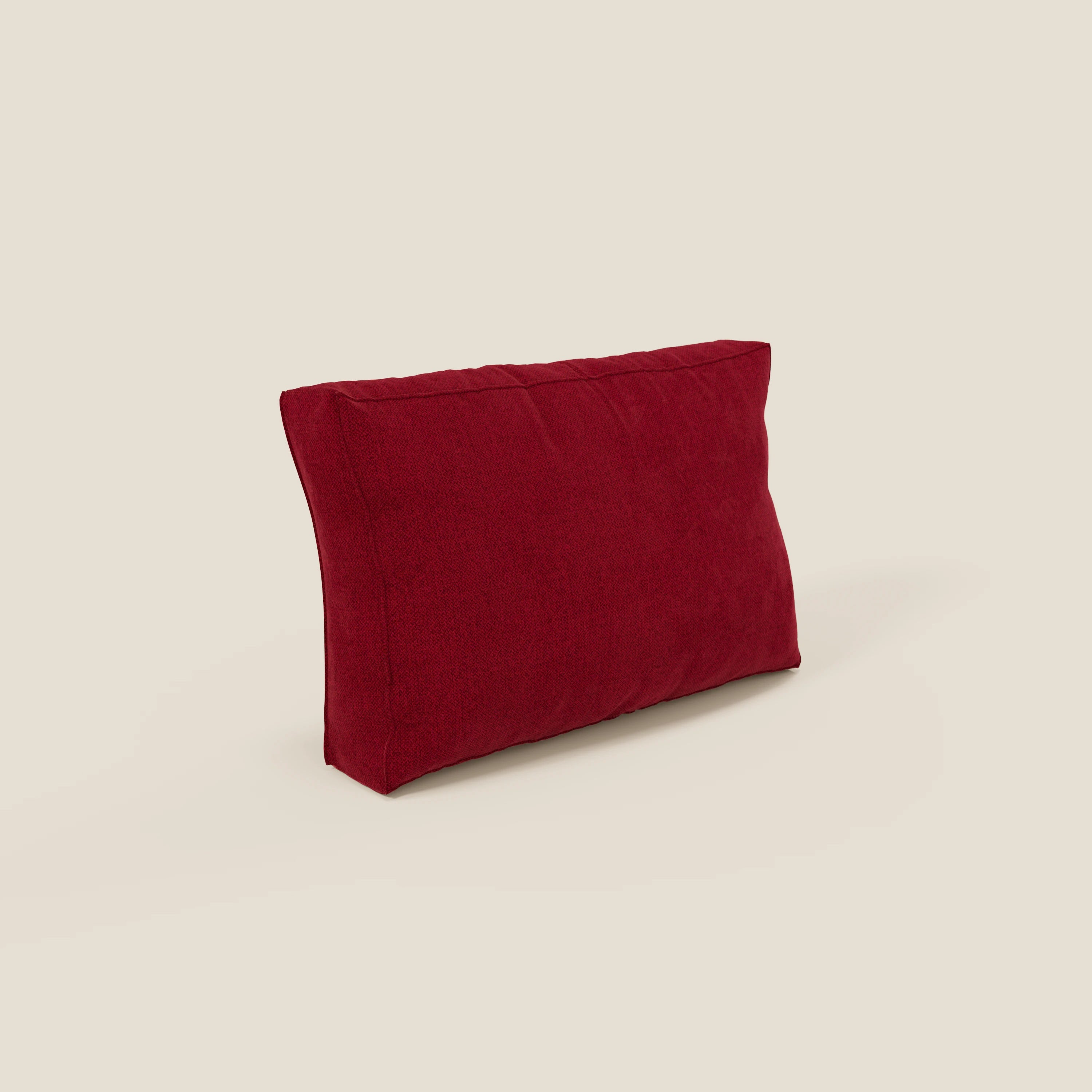 Il cuscino schienale BonBon di Divani.Store, qui presentato in tessuto smacchiabile bordeaux T23, si erge ad angolo su uno sfondo beige chiaro. La sua forma morbida e rettangolare ha bordi ben cuciti ed è disponibile in 2 misure, senza motivi o abbellimenti.