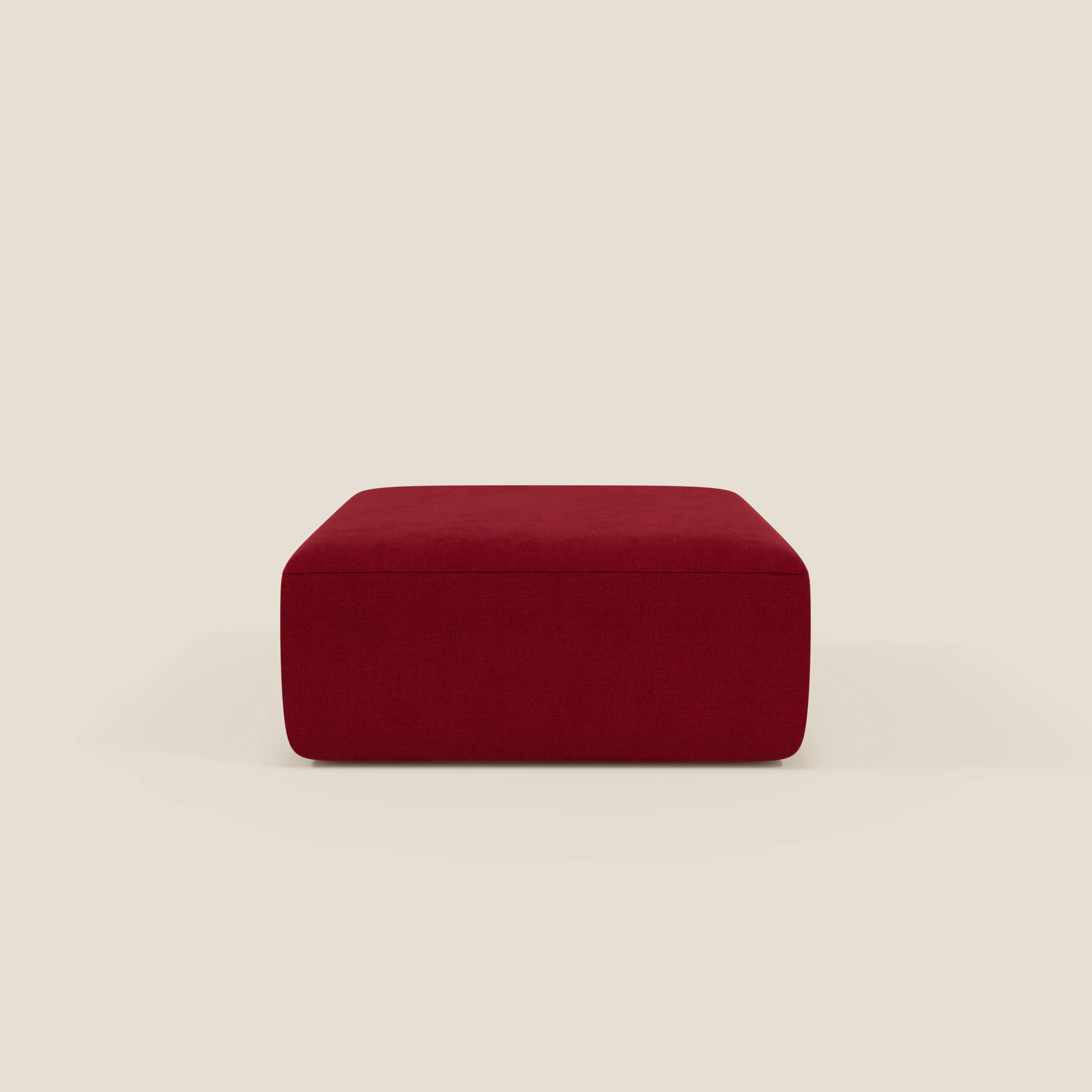 Il pouf BonBon di Divani.Store è un pouf modulare rettangolare di colore bordeaux profondo in tessuto antimacchia T23, caratterizzato da un design semplice e moderno con imbottitura liscia e bordi arrotondati, raffigurato al centro su uno sfondo beige chiaro.