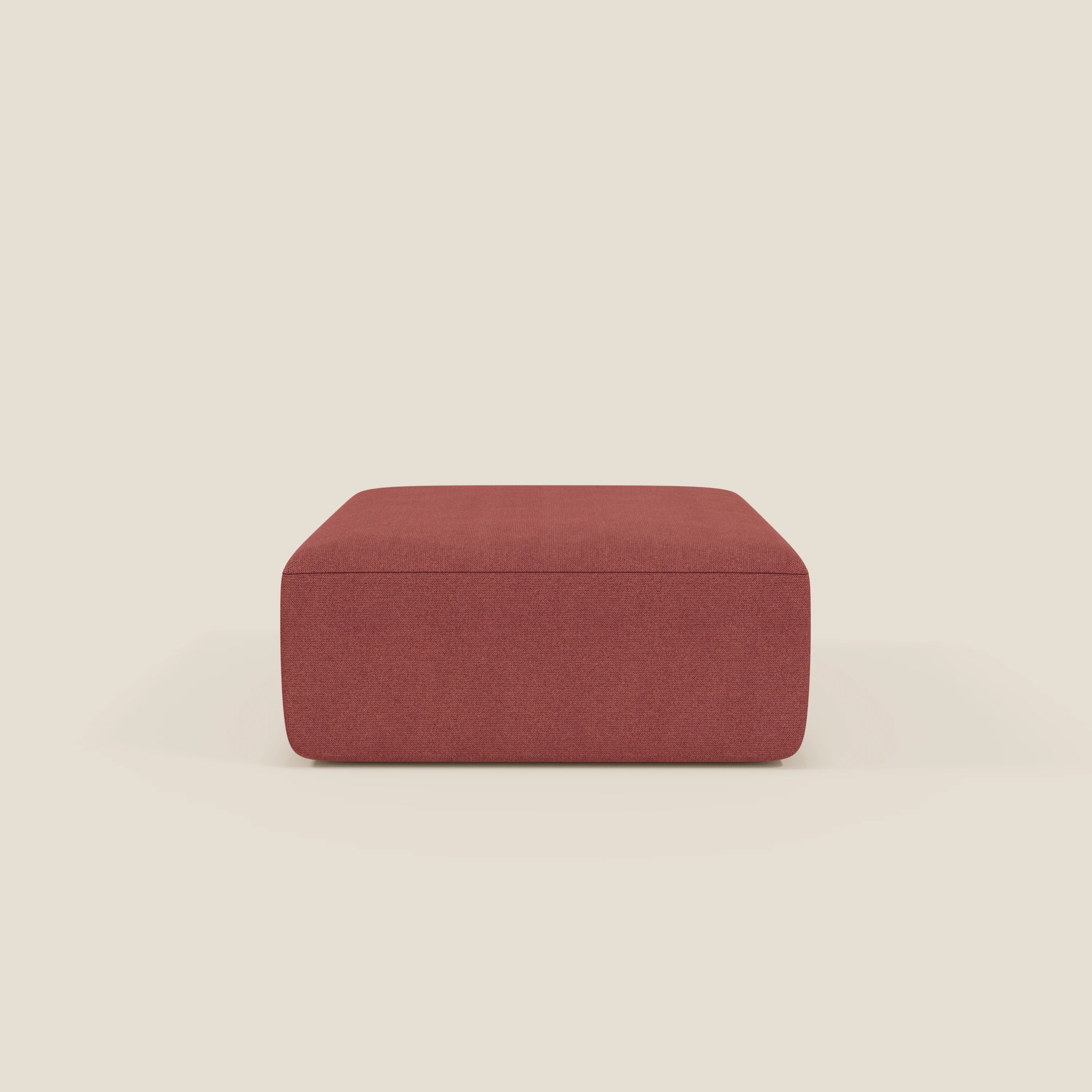 Il pouf BonBon di Divani.Store, un pouf quadrato modulare in tessuto T23 rosso ciliegia antimacchia, presenta linee pulite, un piano piatto e nessuna gamba o decorazione visibile su uno sfondo bianco sporco.