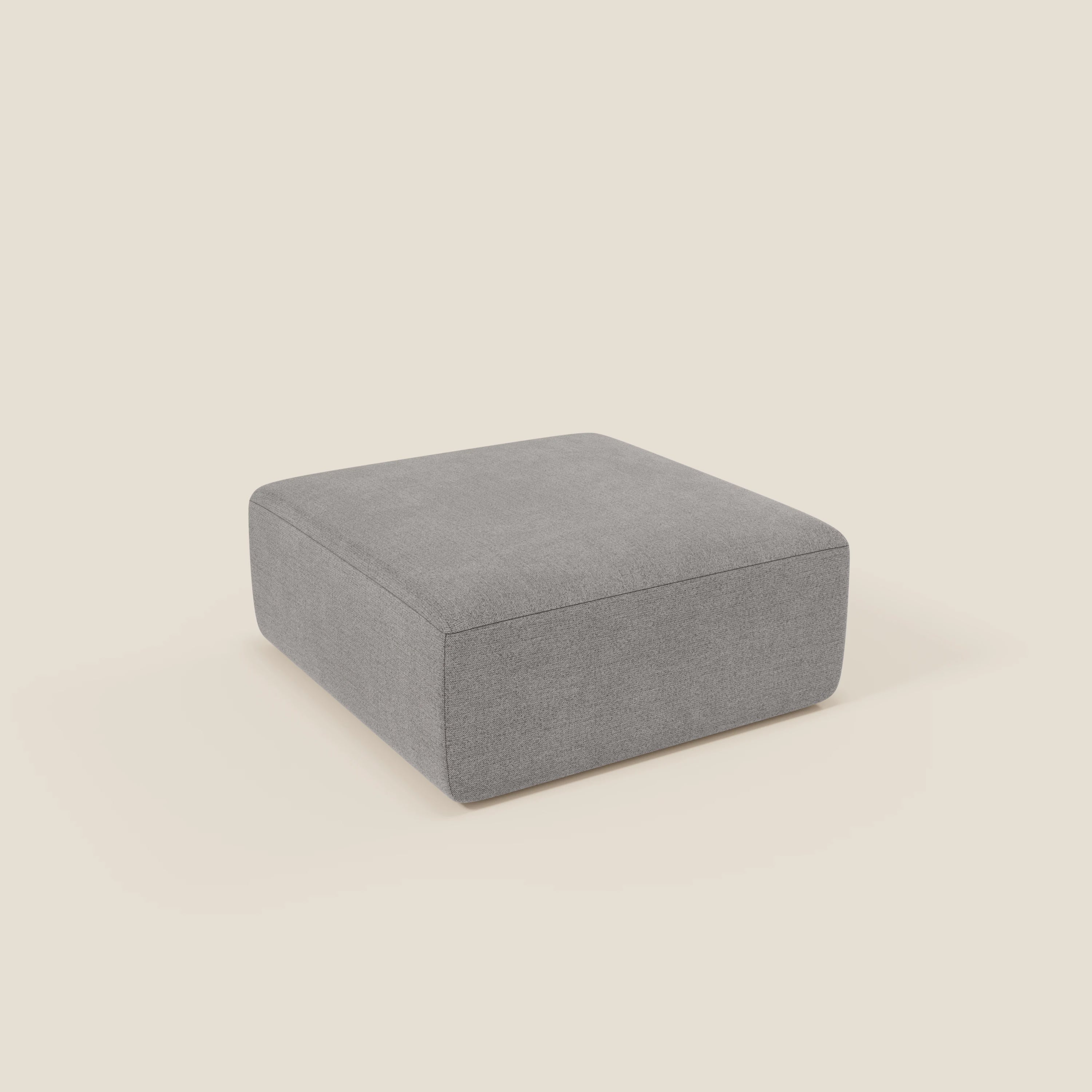 Il pouf divano modulare BonBon di Divani.Store, presentato in tessuto antimacchia T23 grigio, è caratterizzato da un design squadrato e di basso profilo con bordi puliti e senza gambe o decorazioni visibili su uno sfondo bianco sporco.