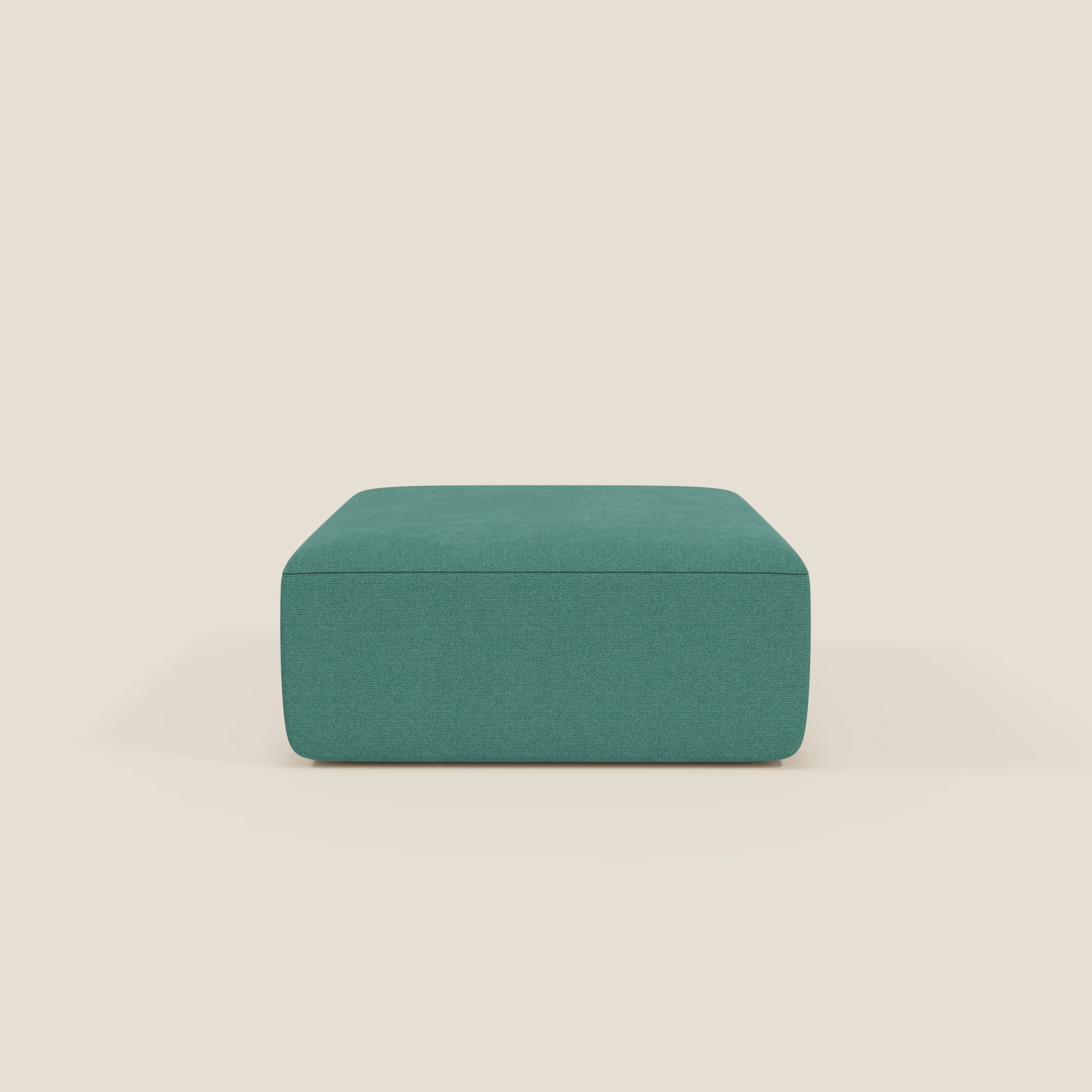 Il pouf quadrato BonBon di Divani.Store in tessuto antimacchia T23 "verde acqua" si staglia su uno sfondo beige chiaro. Il pouf modulare presenta linee pulite, un rivestimento liscio e un design semplice senza gambe visibili.