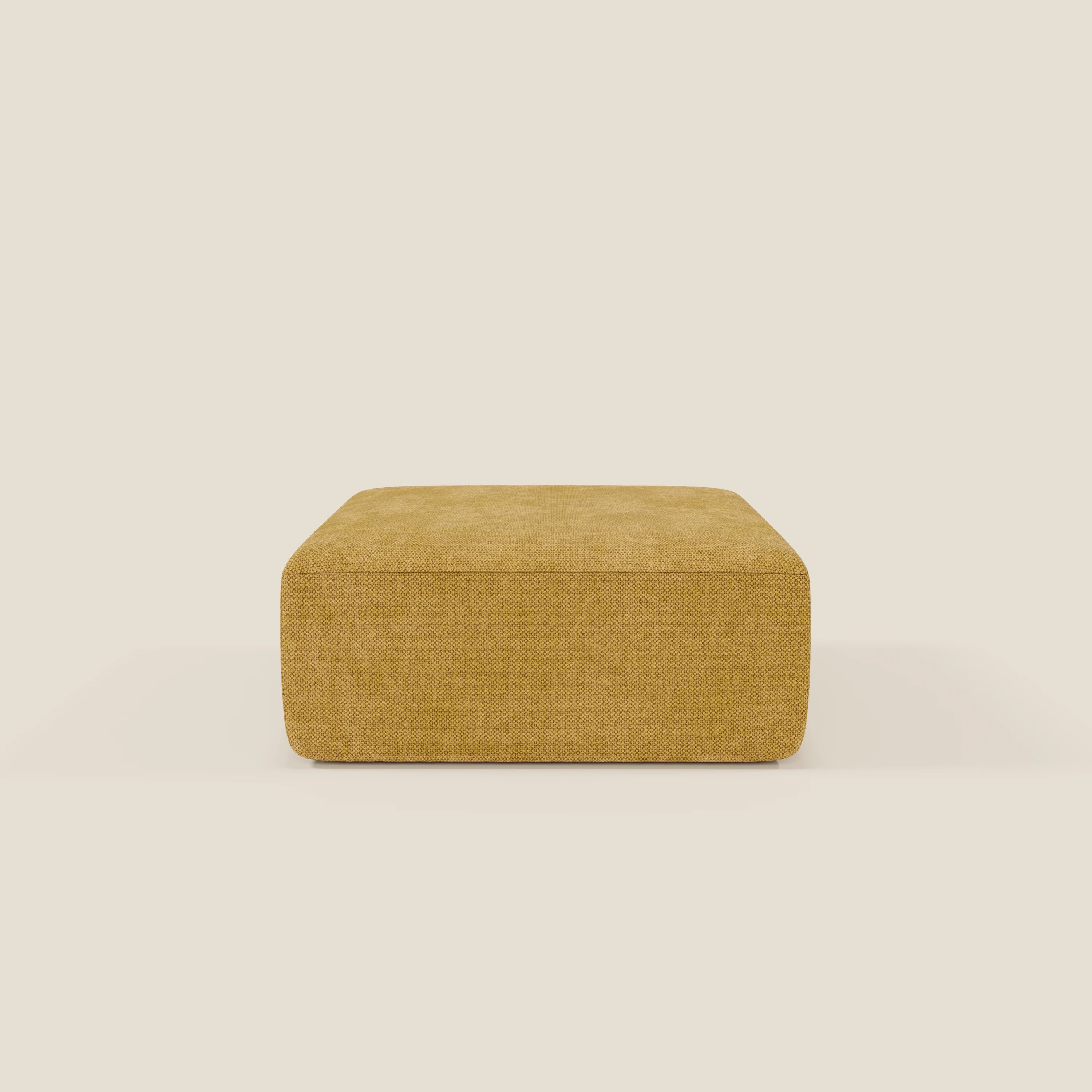 Il pouf BonBon modulo Grande Fratello edition giallo di Divani.Store è un pouf quadrato di colore giallo senape, dal design moderno e minimale e dal rivestimento strutturato, presentato su uno sfondo beige chiaro senza altri oggetti visibili.