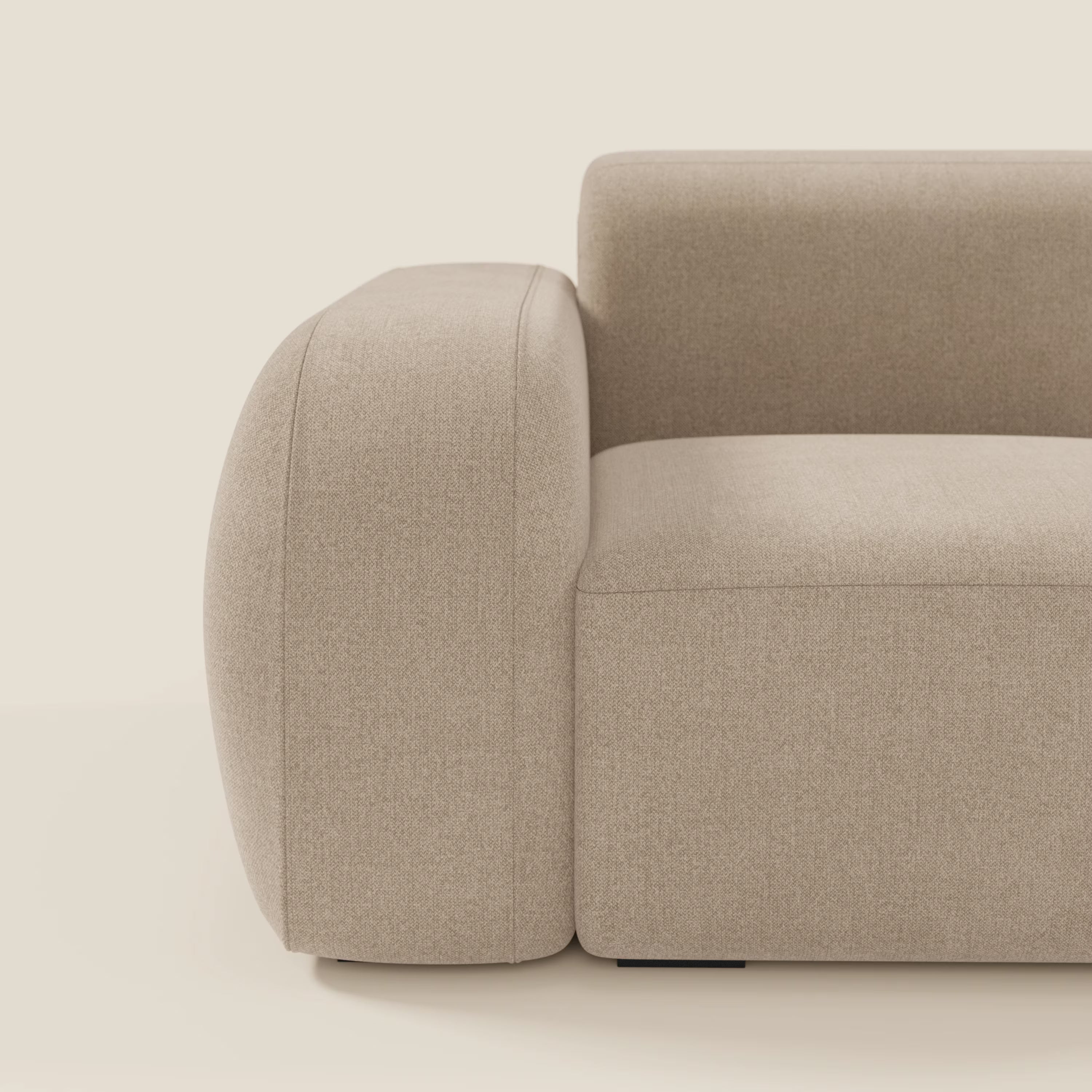 Una vista laterale ravvicinata di BonBon modulo terminale 105 cm sinistro o destro in tessuto smacchiabile T23 beige di Divani.Store, che mostra braccioli spessi e arrotondati e un'imbottitura liscia e minimalista su uno sfondo semplice e bianco sporco.