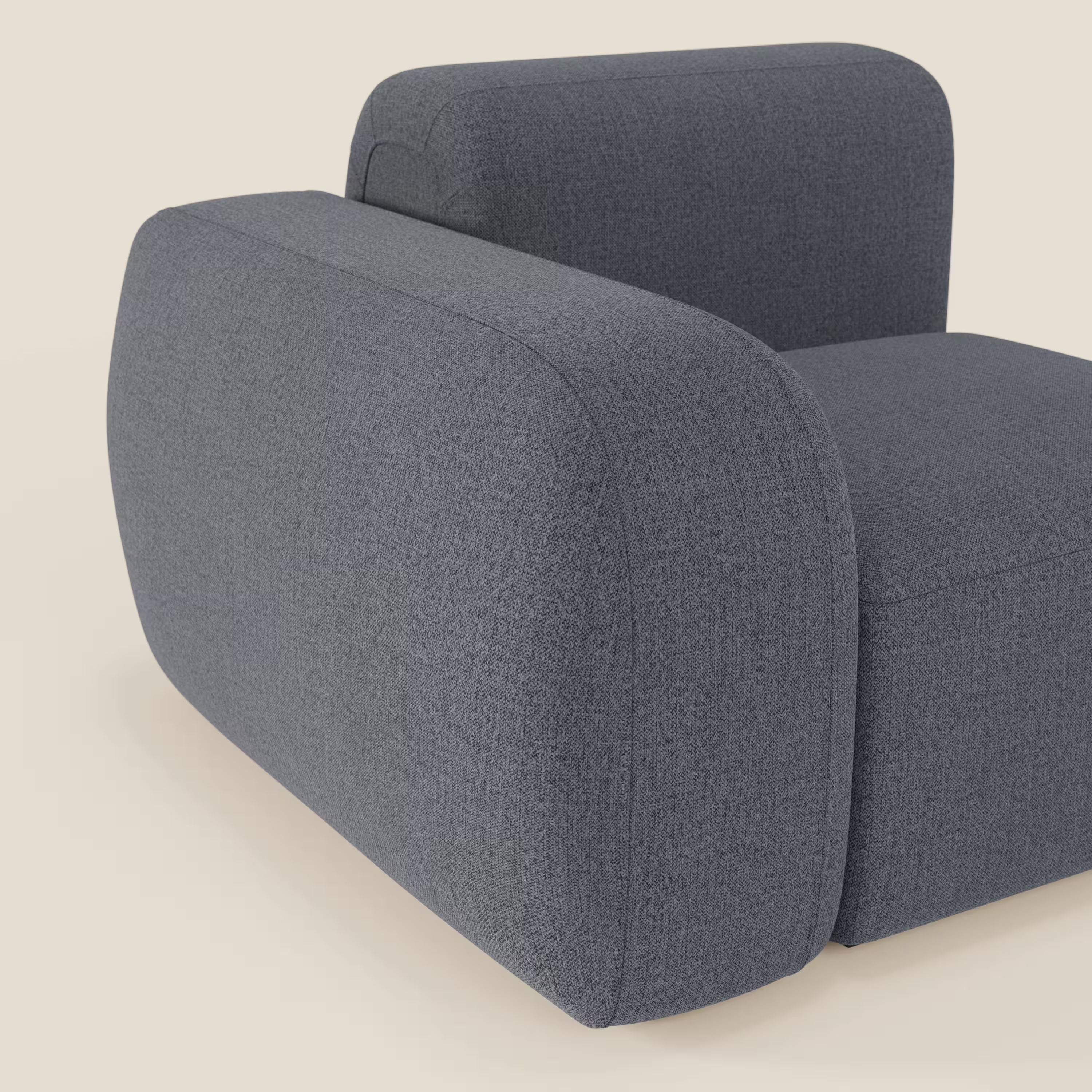 Primo piano del modulo BonBon terminale 105 cm sinistro o destro di Divani.Store in tessuto smacchiabile T23 blu grafite, che mostra parte della seduta e un bracciolo arrotondato su uno sfondo beige chiaro.