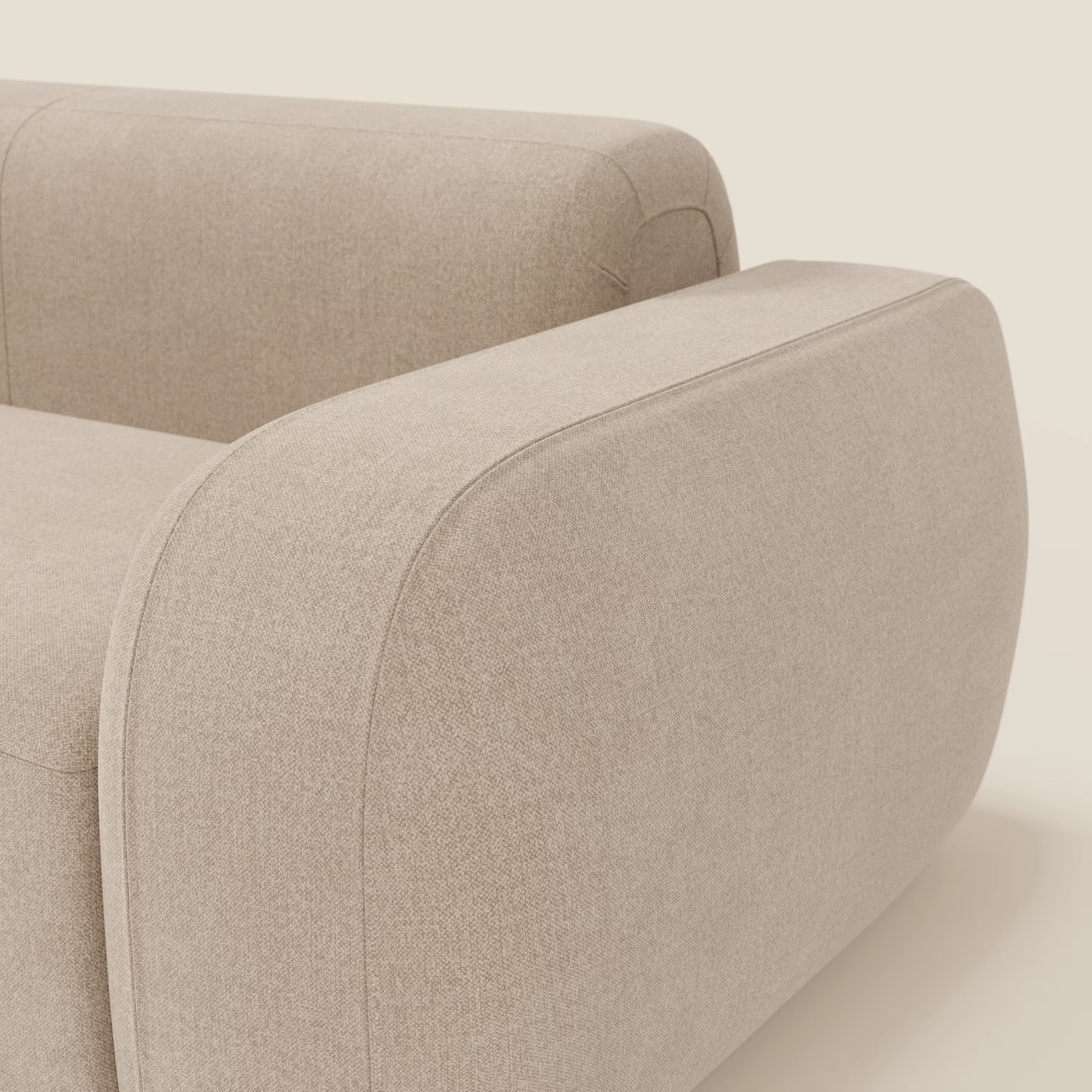 Primo piano del BonBon Divano modulare Lineare 220 di Divani.Store: un divano monoposto beige con bordi dei braccioli arrotondati e linee morbide e minimaliste in tessuto smacchiabile T23, su uno sfondo crema chiaro.