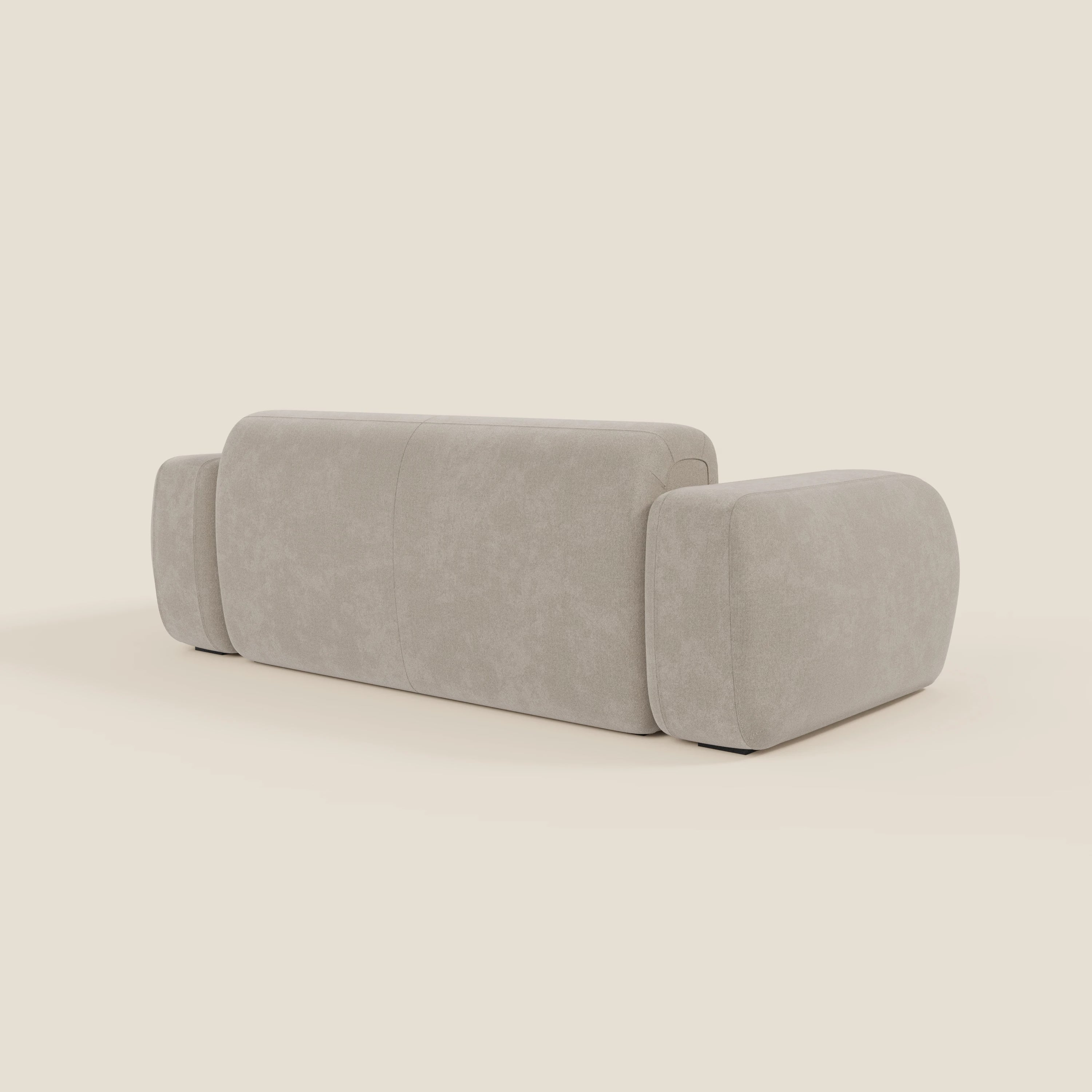 Il BonBon Divano modulare Lineare 220 di Divani.Store è un moderno divano componibile beige in tessuto smacchiabile T23 panna, caratterizzato da braccioli e schienale spessi e arrotondati dal design minimalista, visto da dietro su uno sfondo bianco sporco.