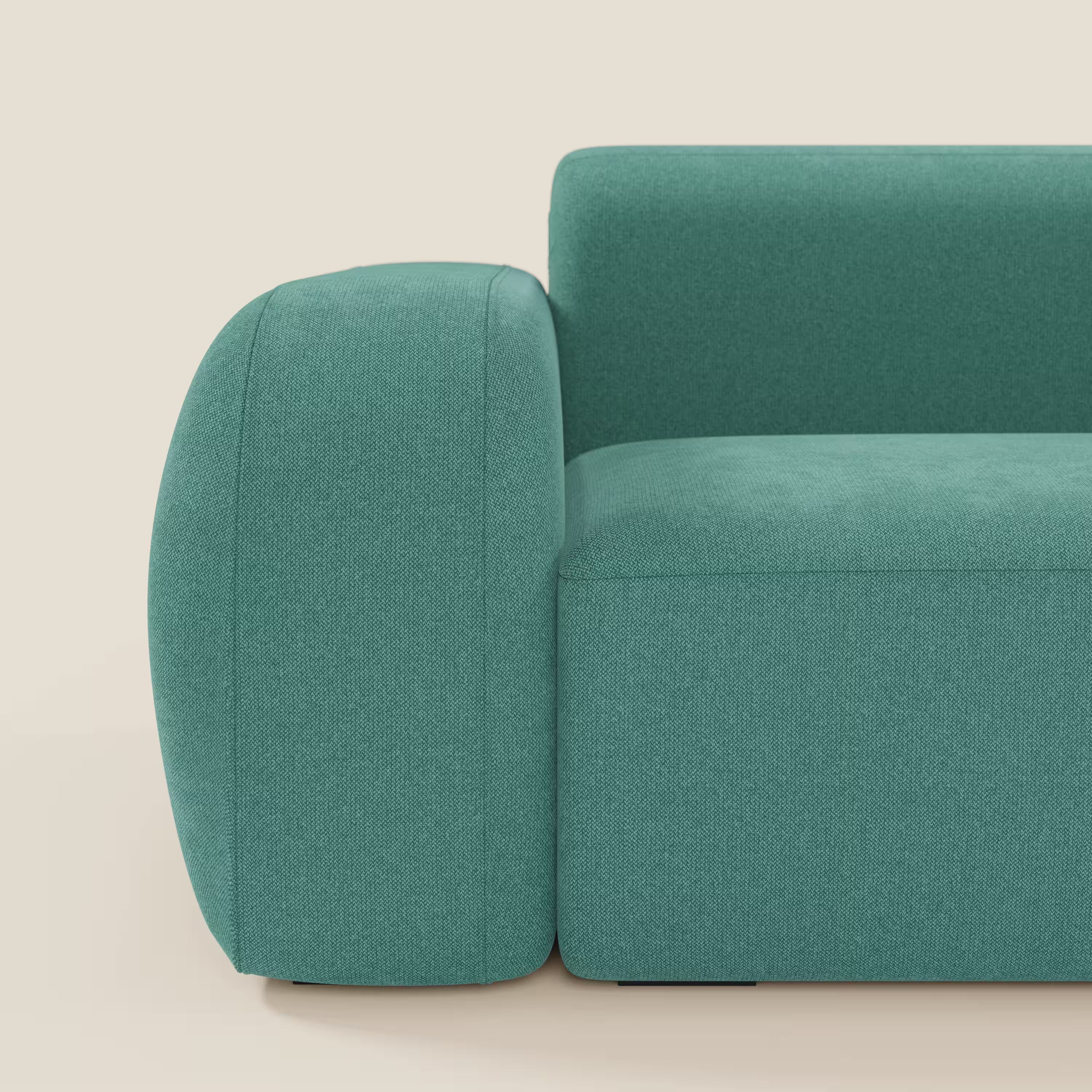 Il BonBon Divano modulare Lineare 220 di Divani.Store è un divano moderno e compatto di colore verde acqua dal design squadrato. In primo piano, il tessuto smacchiabile T23 verde acqua riveste il bracciolo sinistro, il cuscino e lo schienale su uno sfondo bianco sporco.