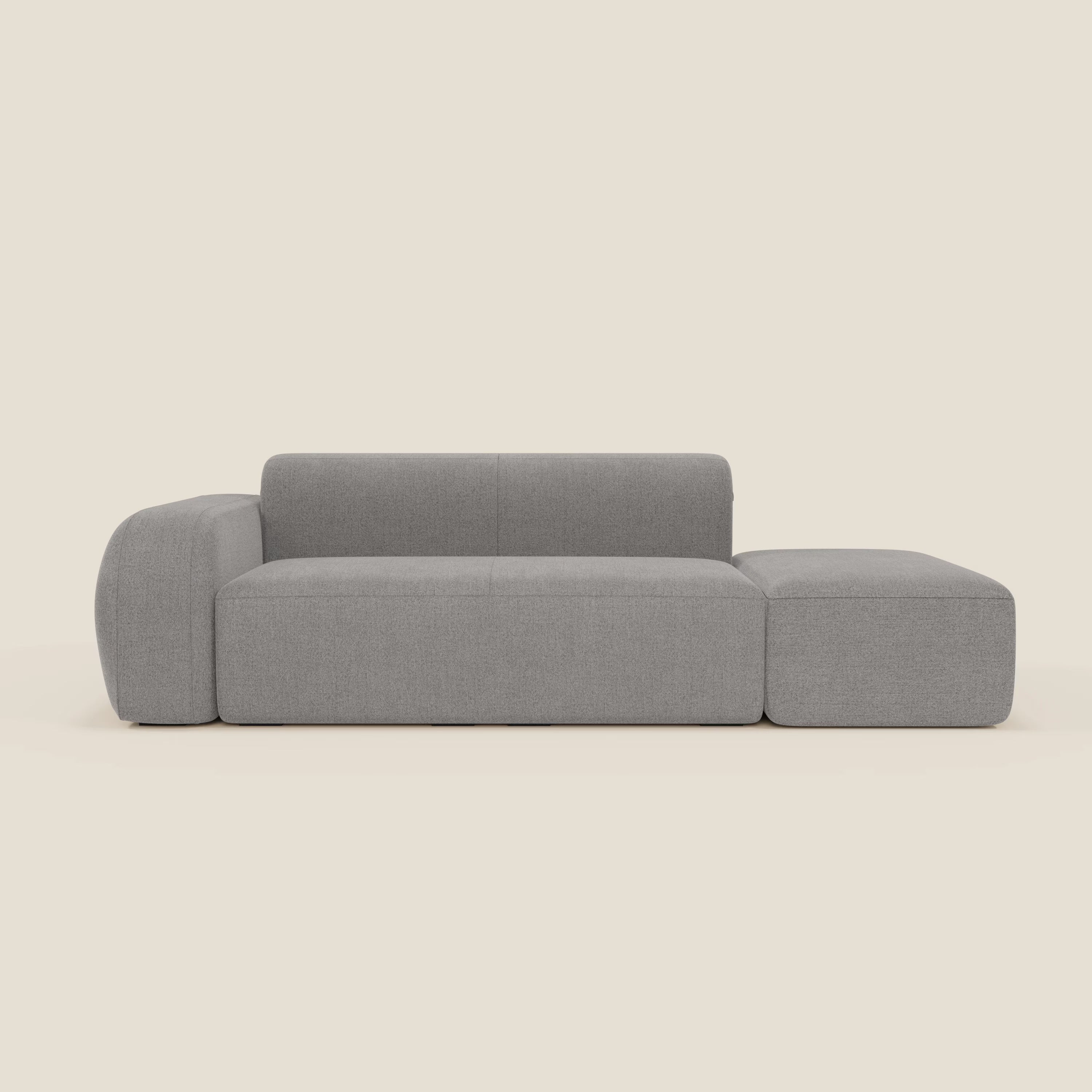 BonBon Divano componibile di Divani.Store è caratterizzato da uno schienale basso, da un pouf terminale sul lato destro e da un tessuto antimacchia grigio T23, su uno sfondo beige chiaro che ne sottolinea il design minimalista e squadrato.
