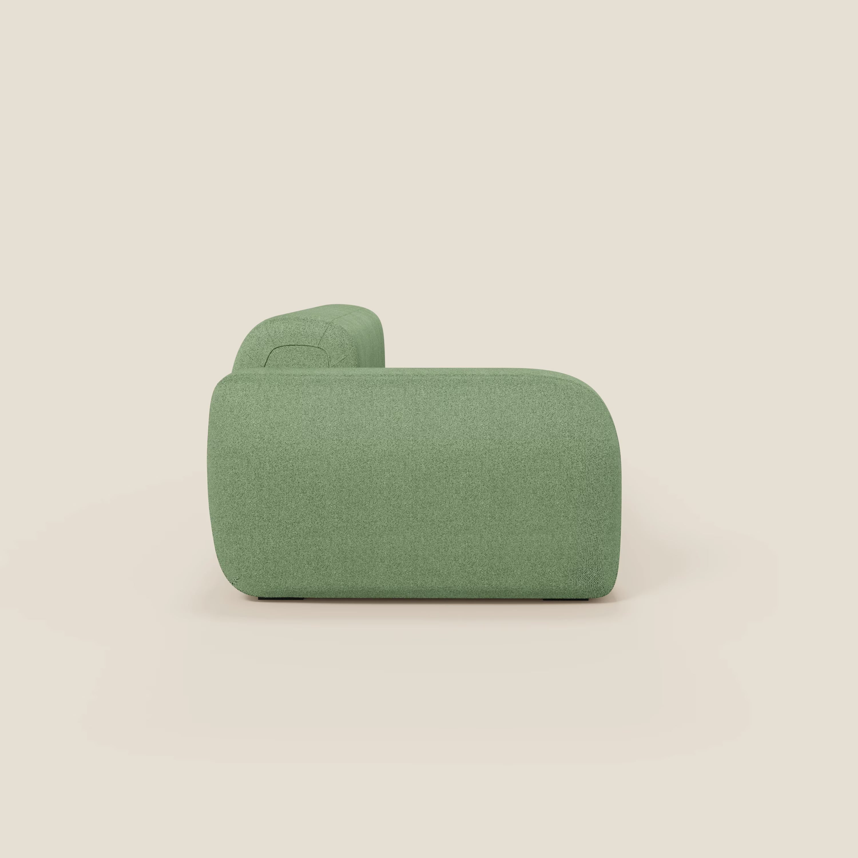 Vista laterale di BonBon Divano componibile di Divani.Store, con pouf terminale in tessuto antimacchia T23 menta. Lo sfondo bianco sporco mette in risalto i bordi arrotondati e il design elegante e minimalista.