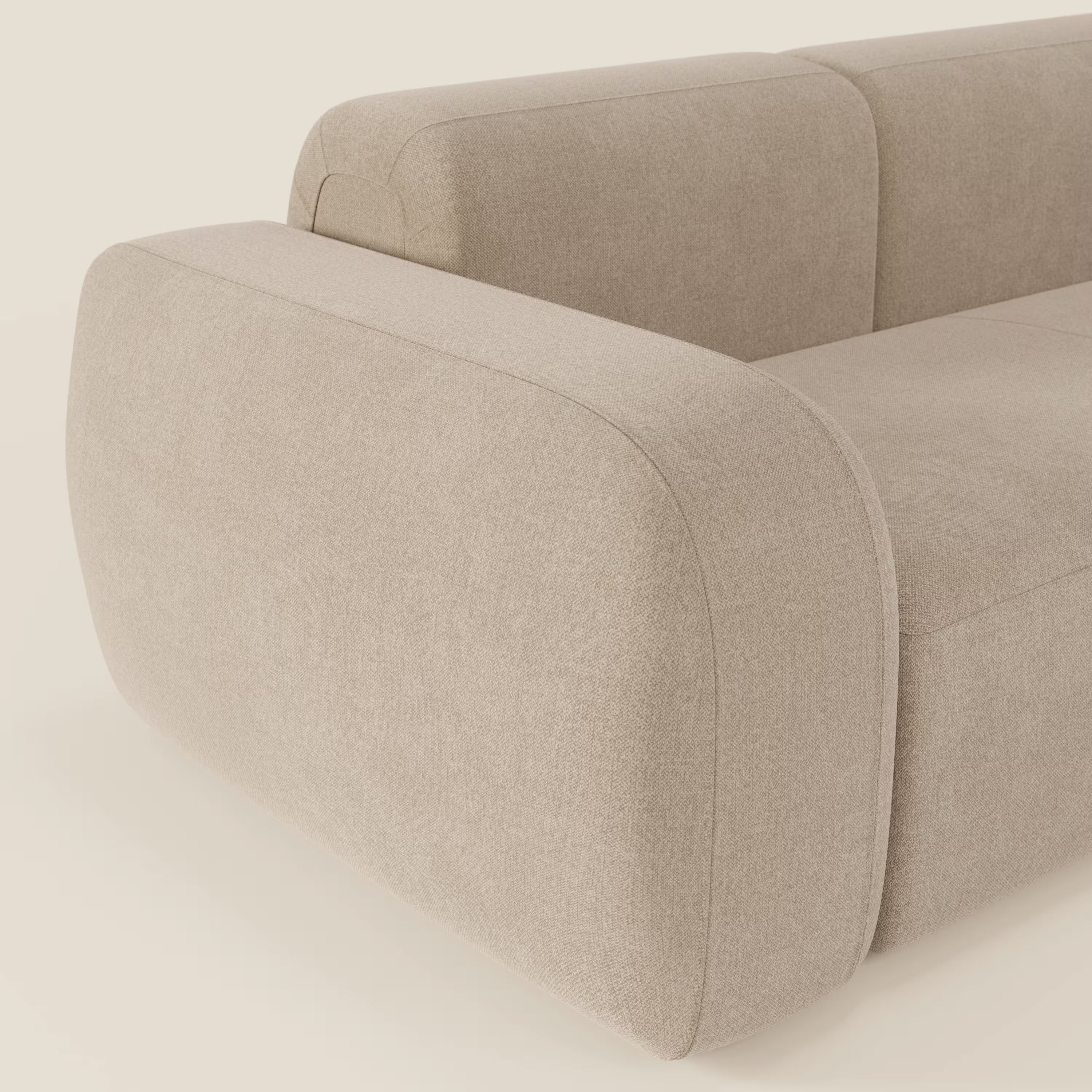 Primo piano del divano componibile BonBon - Composizione Spaccamattone di Divani.Store in tessuto antimacchia T23 beige, caratterizzato da ampi braccioli arrotondati, una texture morbida e un design contemporaneo unico e invitante.