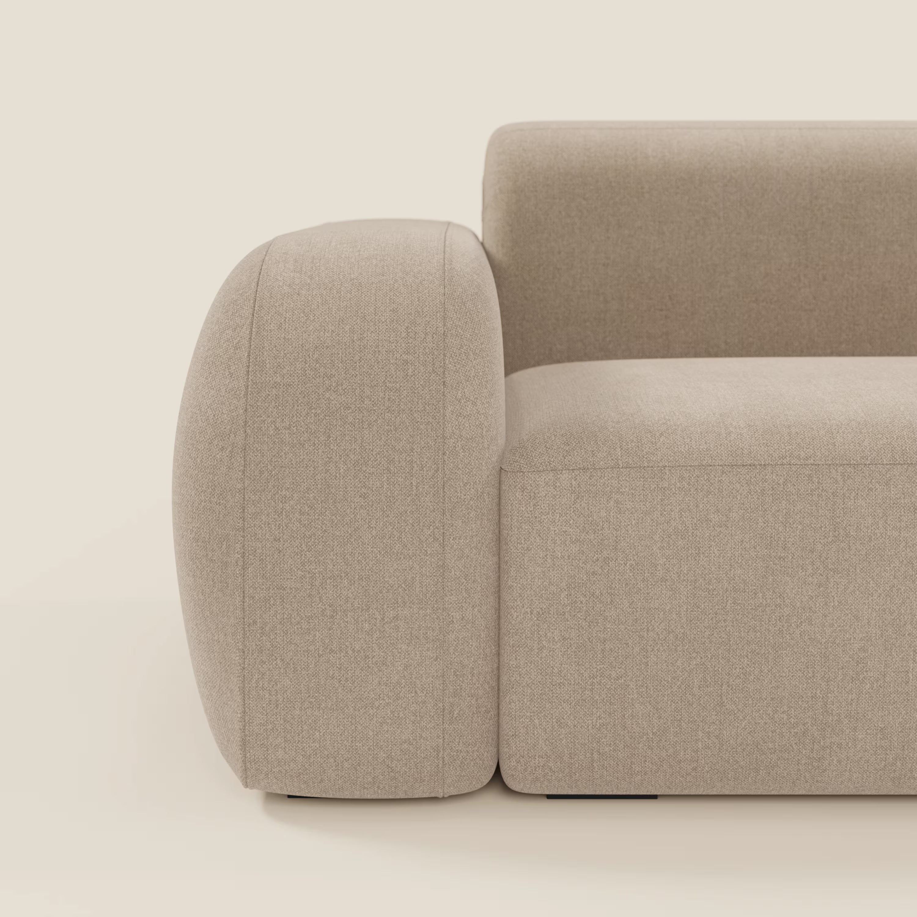 Vista laterale ravvicinata di BonBon Divano modulare componibile - Composizione Spaccamattone in tessuto smacchiabile T23 beige di Divani.Store, che mostra i braccioli arrotondati, l'imbottitura liscia e le linee minimaliste su uno sfondo neutro.